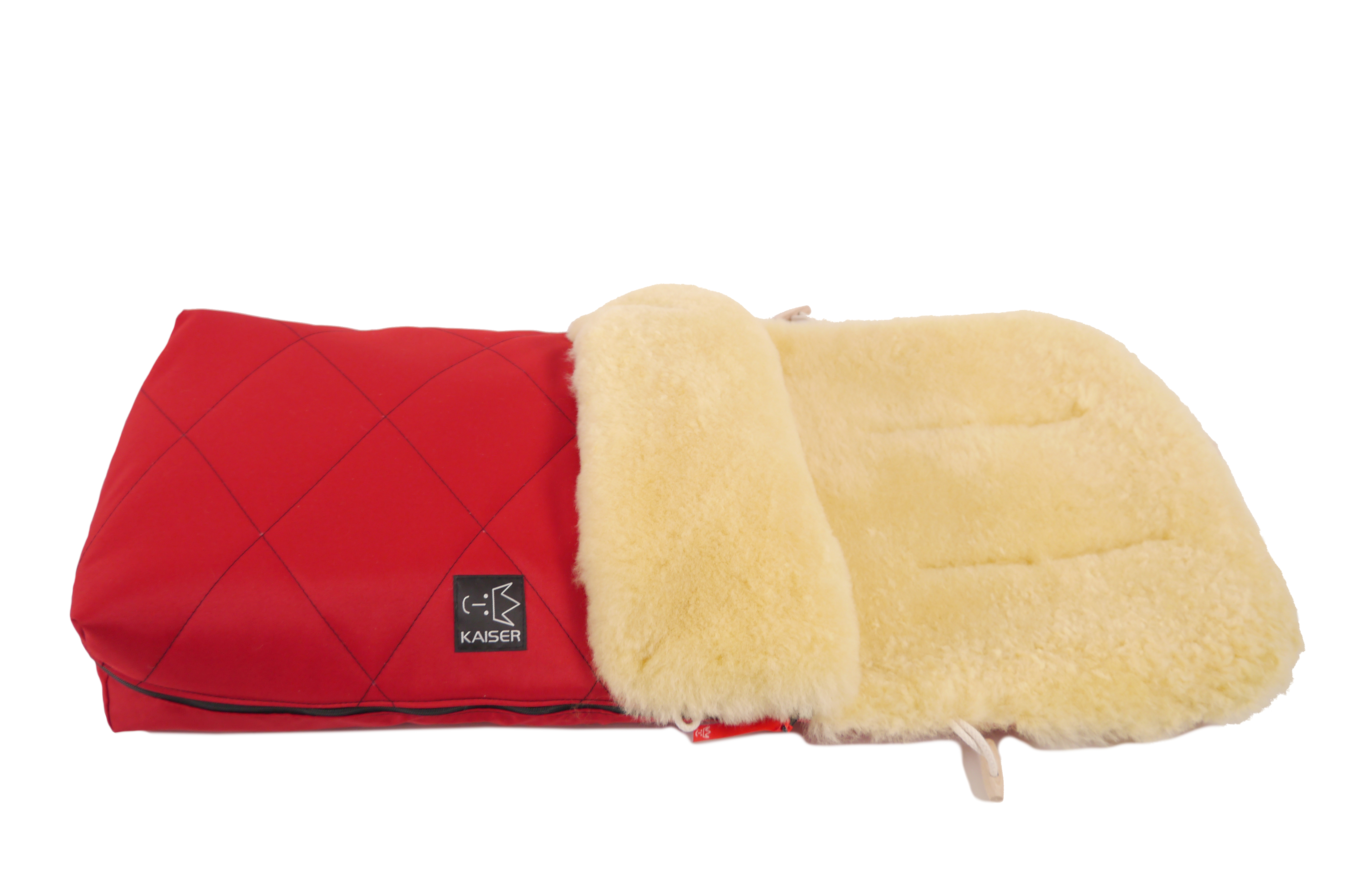 Fußsack mit dem Lammfell-Innenfutter in der Farbe rot und schwarzem „Kaiser“-Logo auf der Vorderseite liegt horizontal