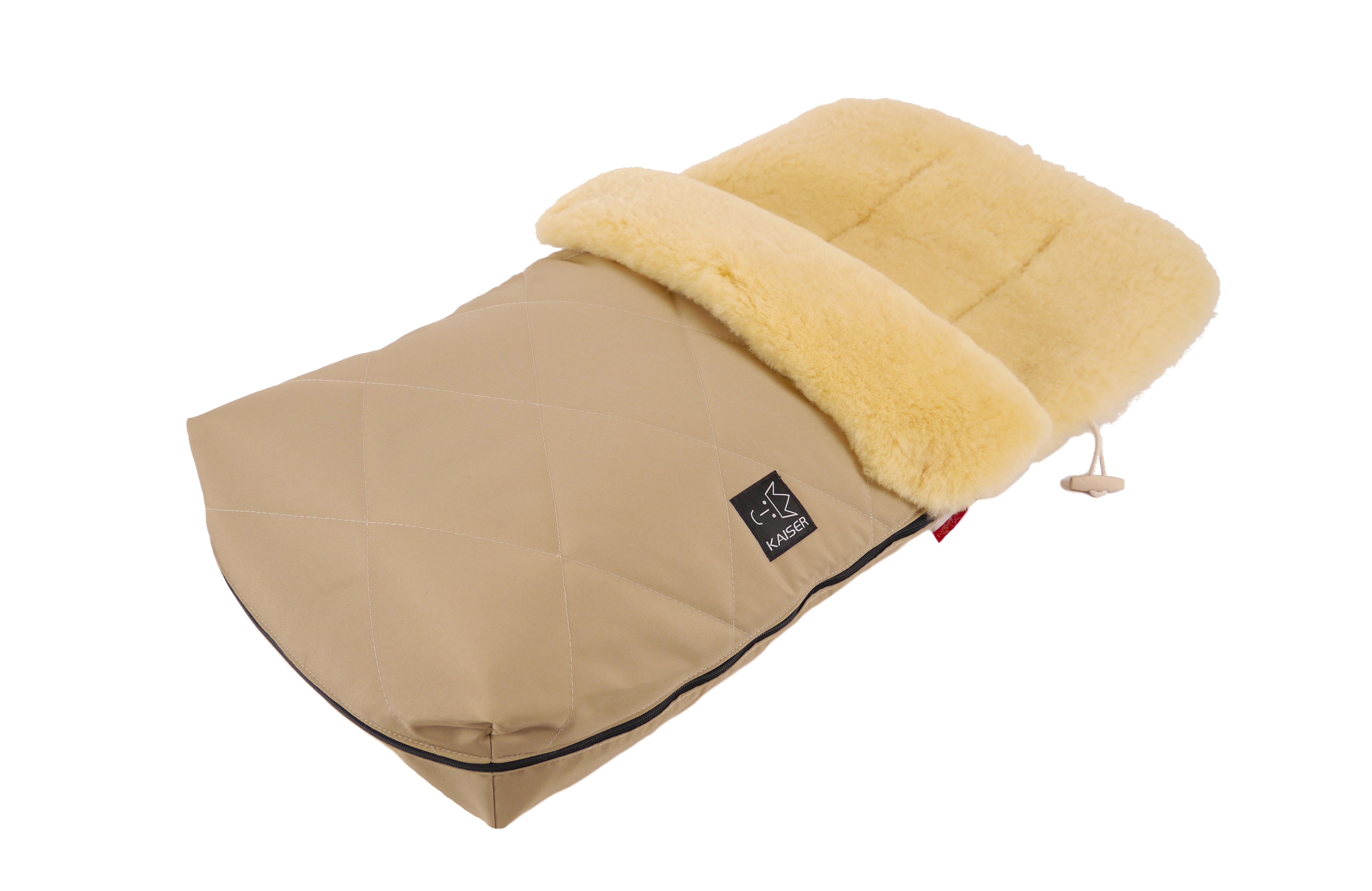 Fußsack mit dem Lammfell-Innenfutter in der Farbe sand und schwarzem „Kaiser“-Logo auf der Vorderseite liegt quer