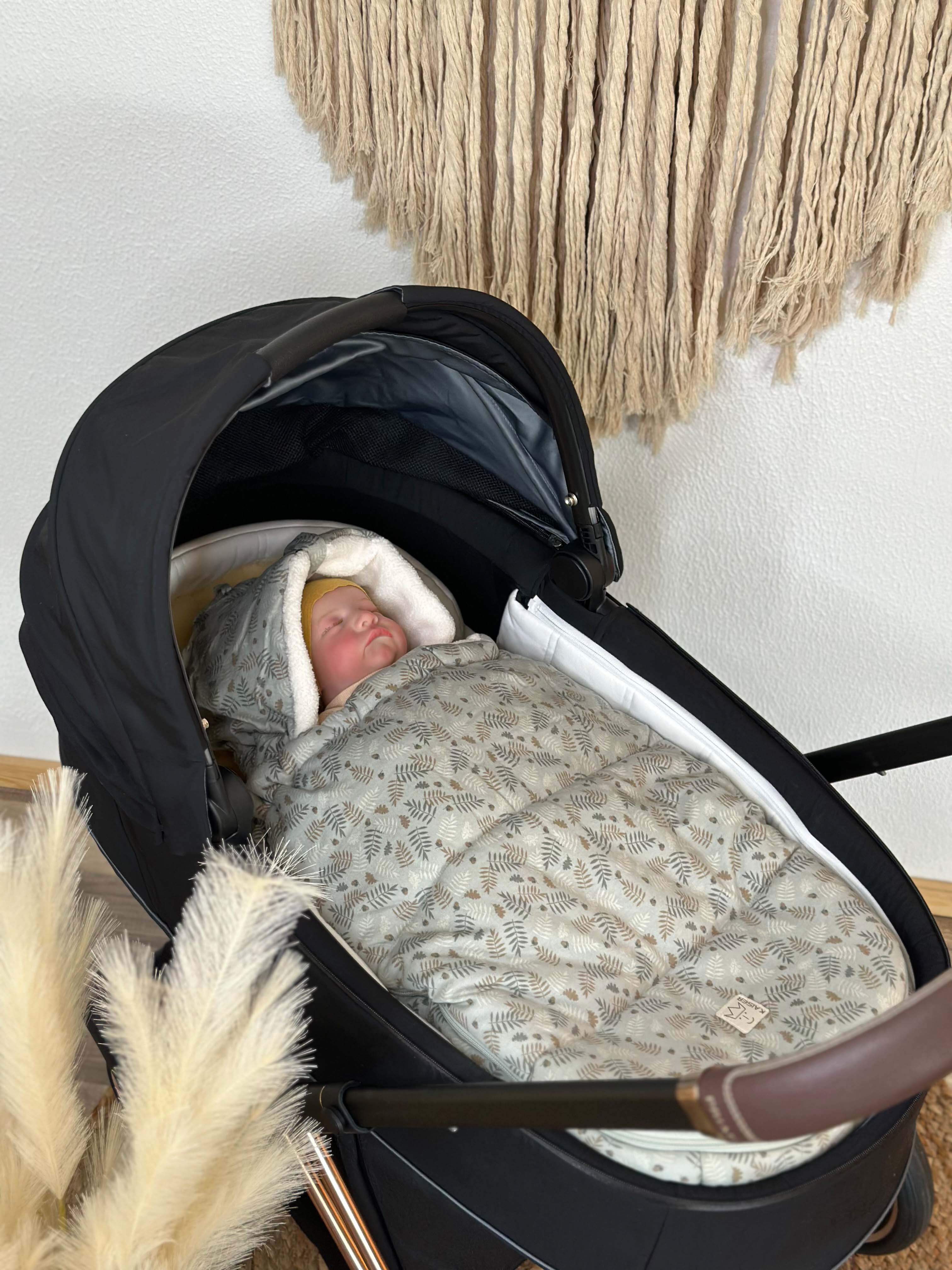 Baby in Babyschale mit Kaiser Jersey Hood Winter in der Farbe forrest green mit abnehmbarem Oberteil