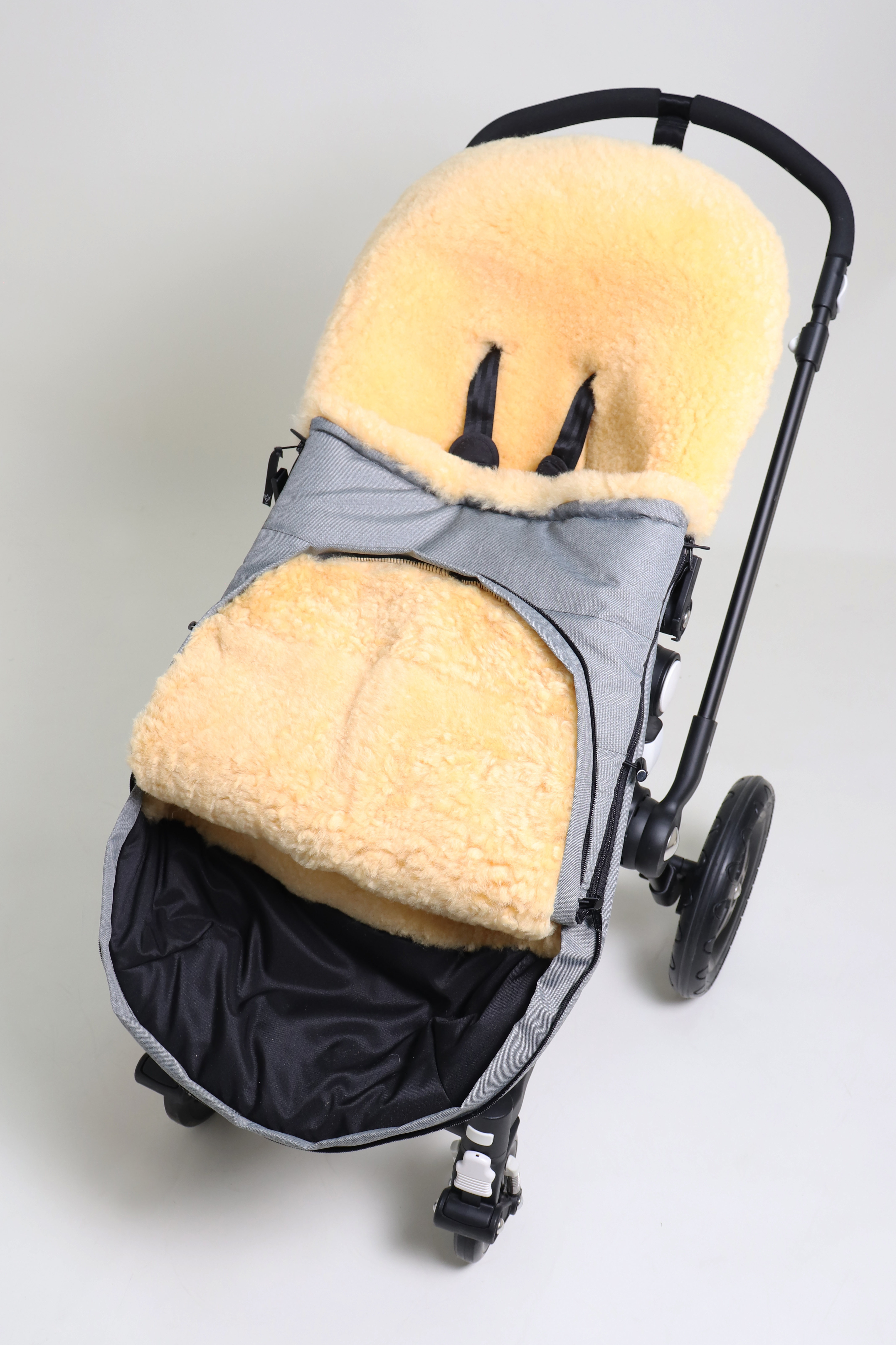 Fußsack mit dem Lammfell-Innenfutter in light-grey-melange in einem Kinderwagen eingesetzt