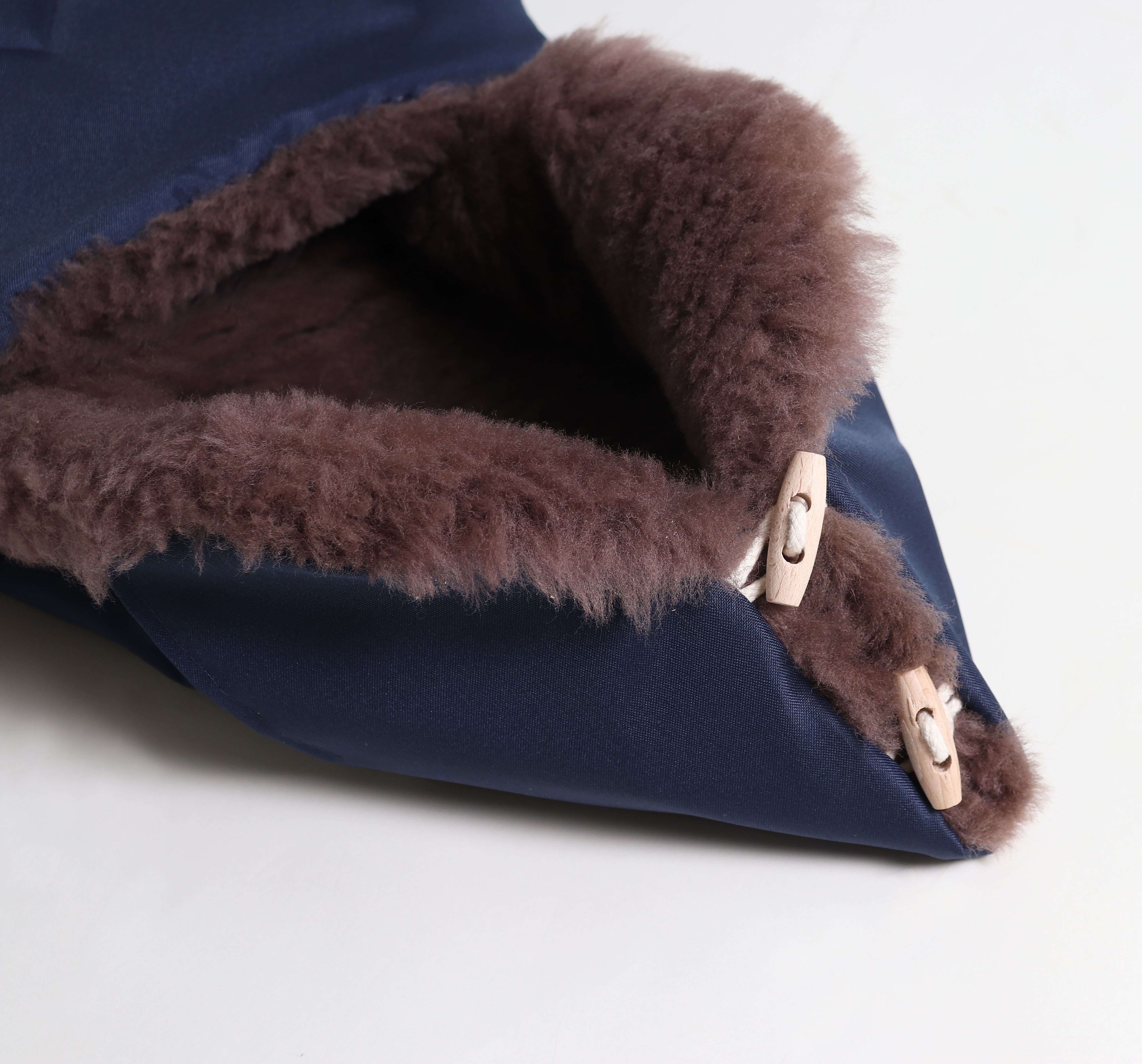 Detail: Reißverschluss und Holzknöpfe an TOFFEE Lammfell Fußsack