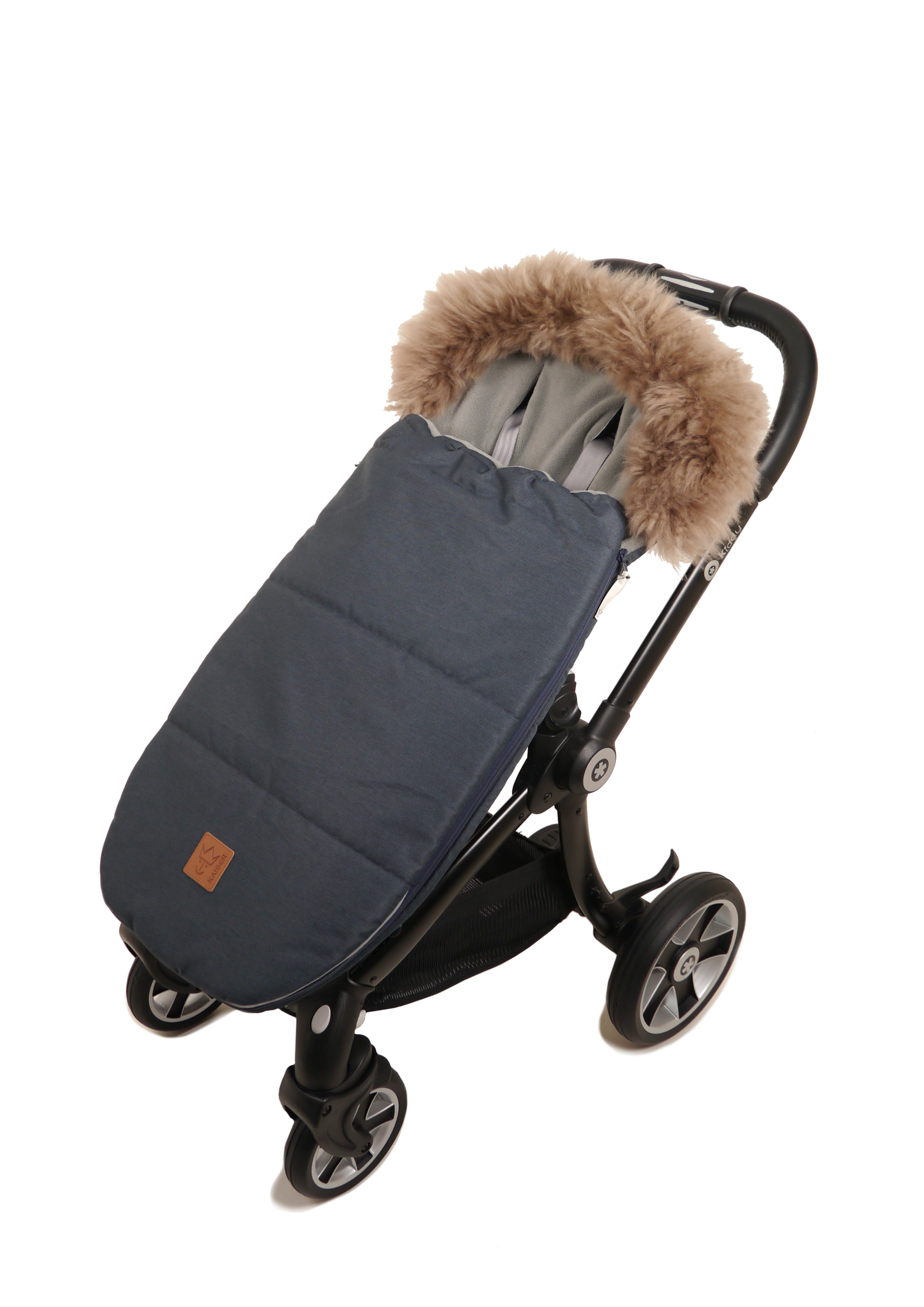 Kaiser Fußsack in der Farbe denim blue mit braunem Fellrand und grauem Fleece-Innenfutter im Kinderwagen montiert