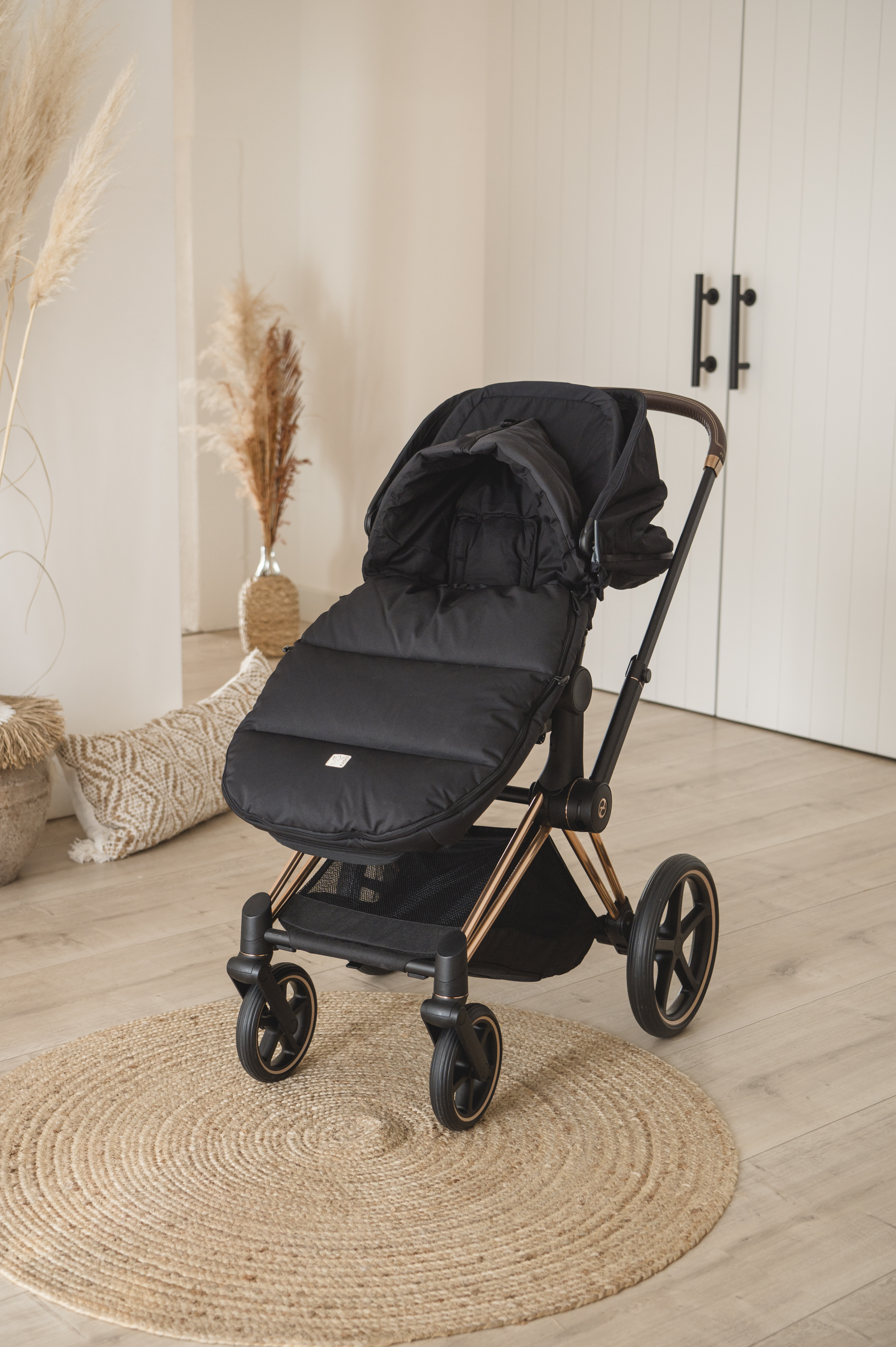 Thermofußsack in schwarz ist in einem Kinderwagen eingesetzt