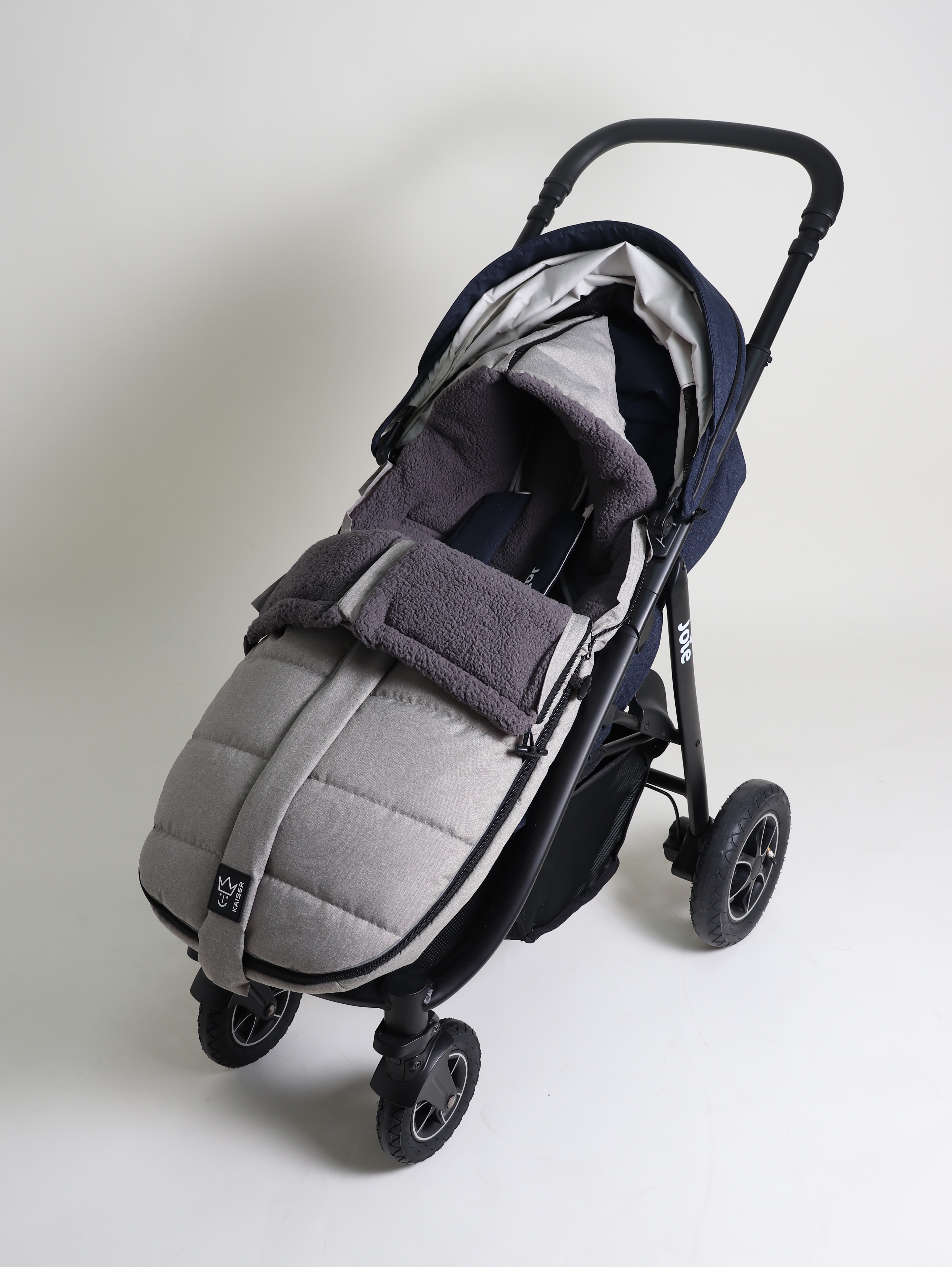 MILA Thermo-Fußsack Geschlossener Fußsack mit einem Sherpa-Futter in der Farbe light-grey melange ist in einem Kinderwagen eingesetzt