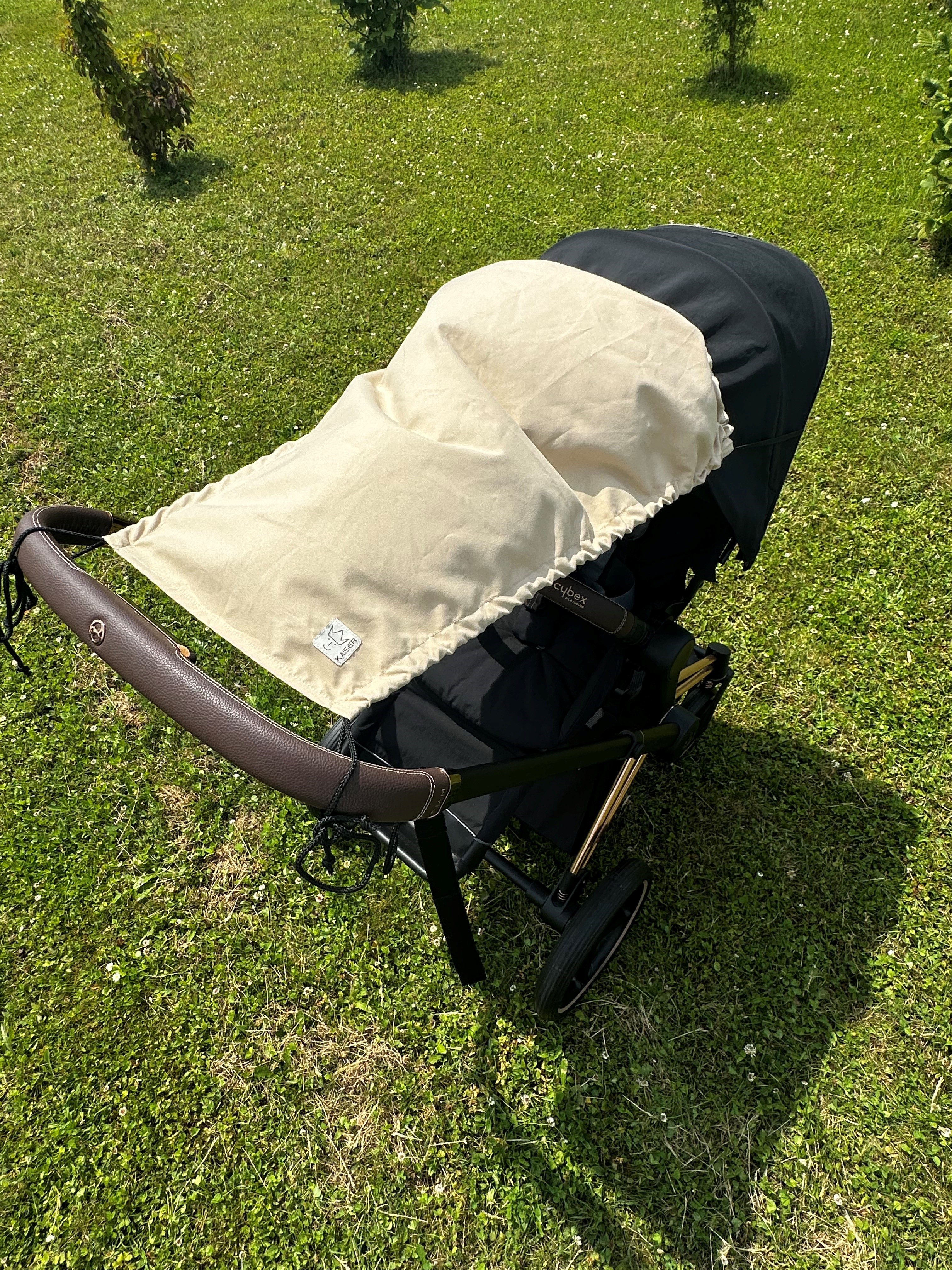 Sonnensegel in sand an Kinderwagen befestigt