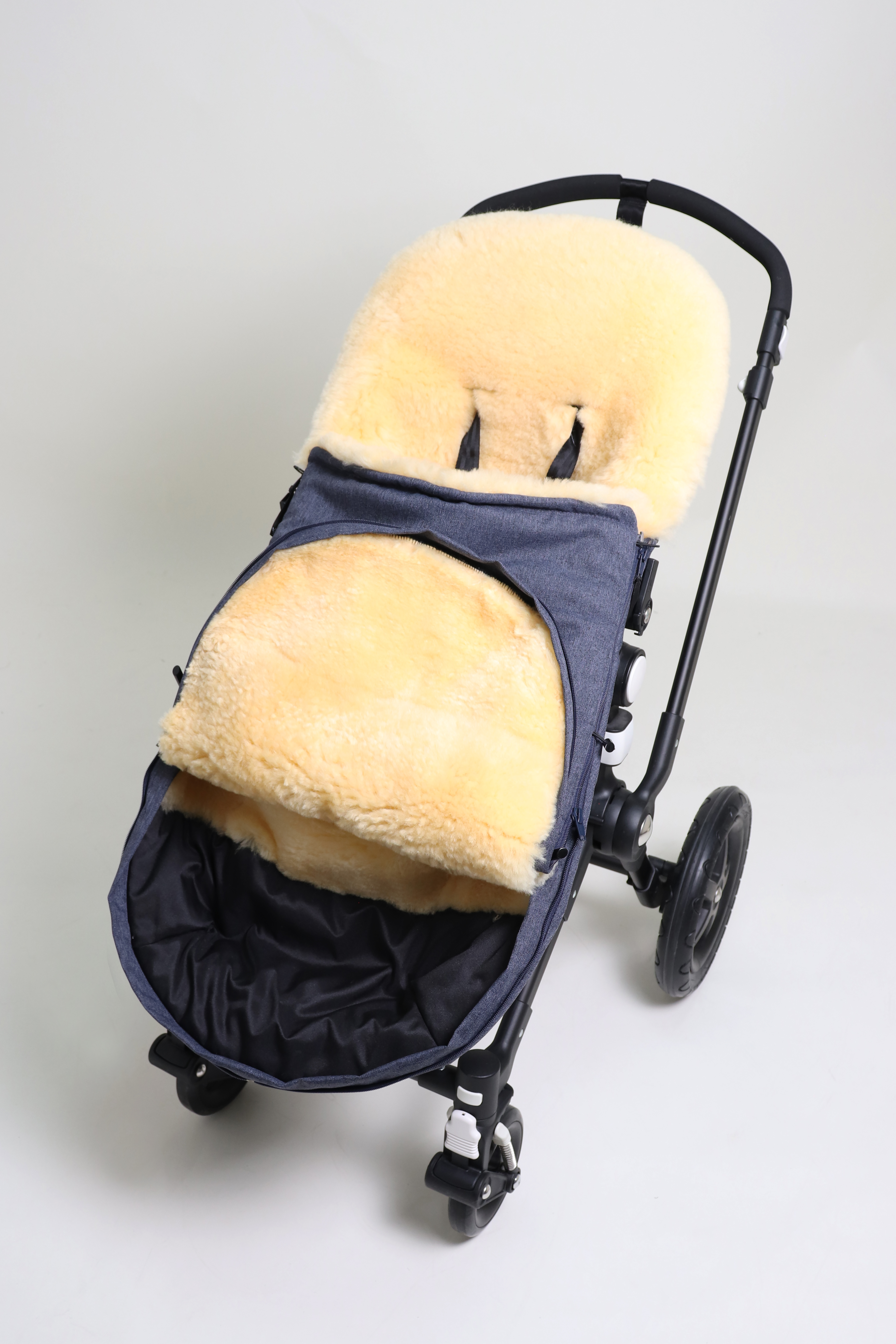 Fußsack mit dem Lammfell-Innenfutter in navy-melange in einem Kinderwagen eingesetzt