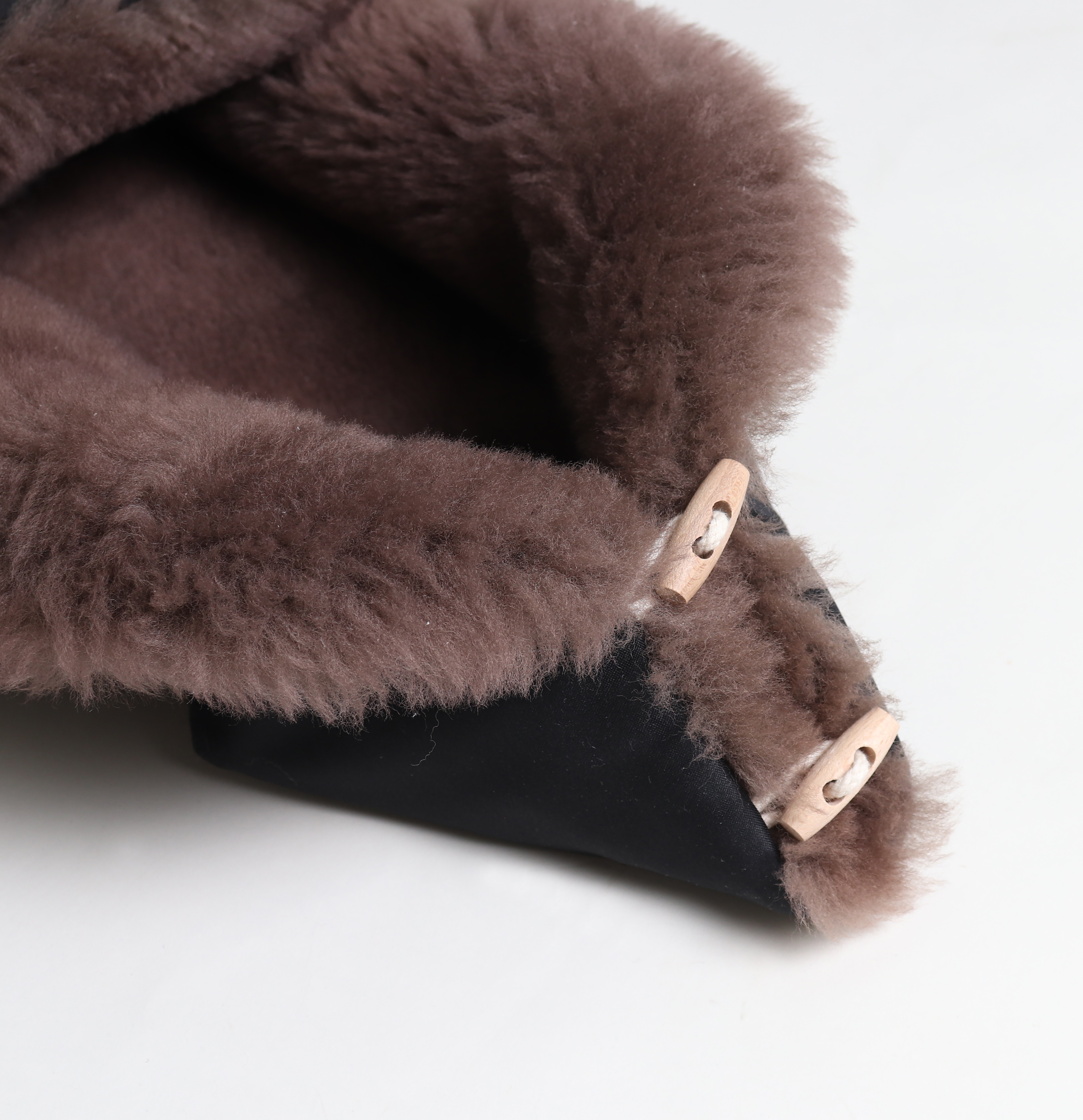 Detail: Reißverschluss und Holzknöpfe an TOFFEE Lammfell Fußsack