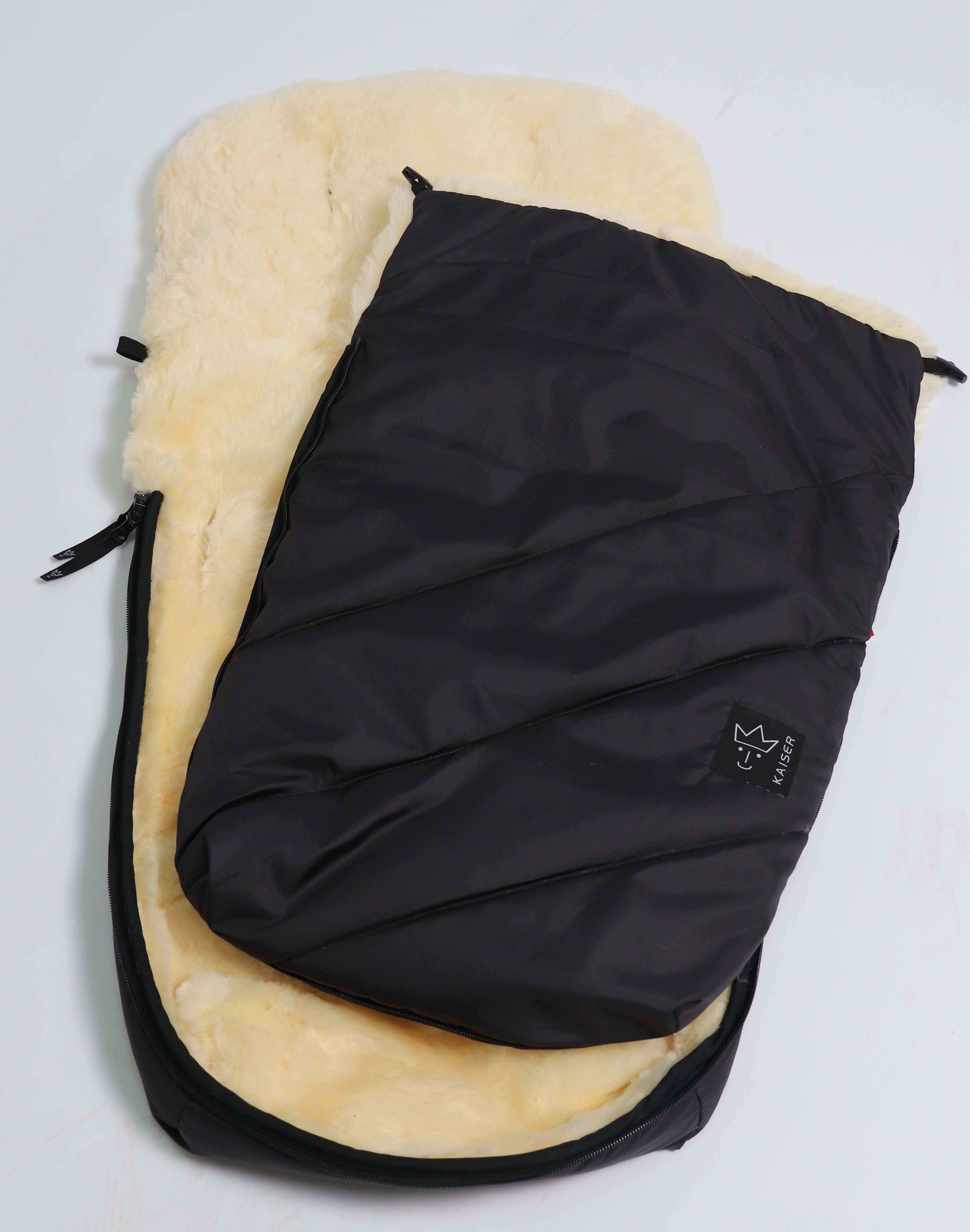 schwarzer Fußsack mit dem Lammfell-Innenfutter seitlich geöffnet und aufgeklappt