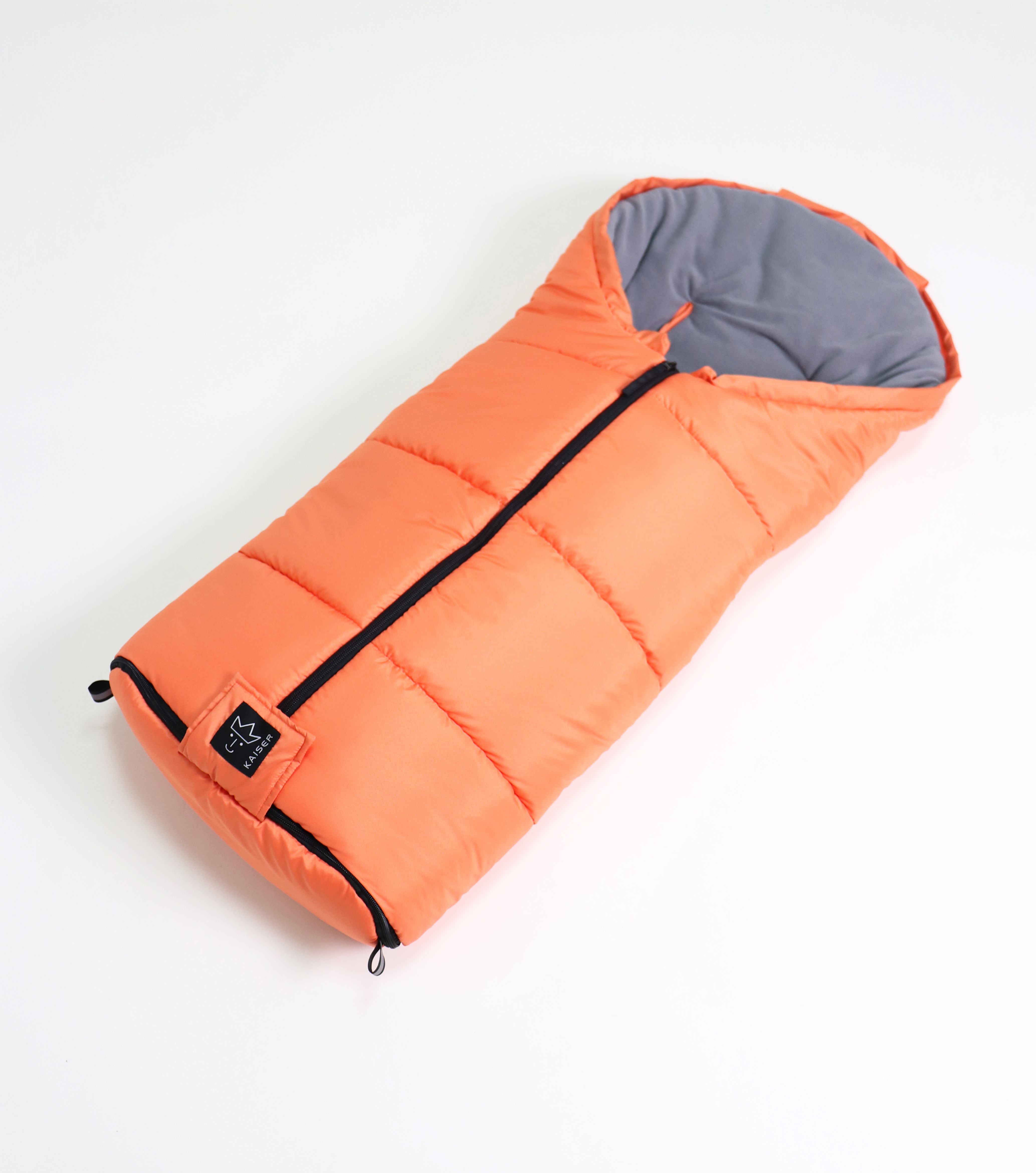 Fußsack mit einem Sherpa-Futter in der Farbe orange liegt quer