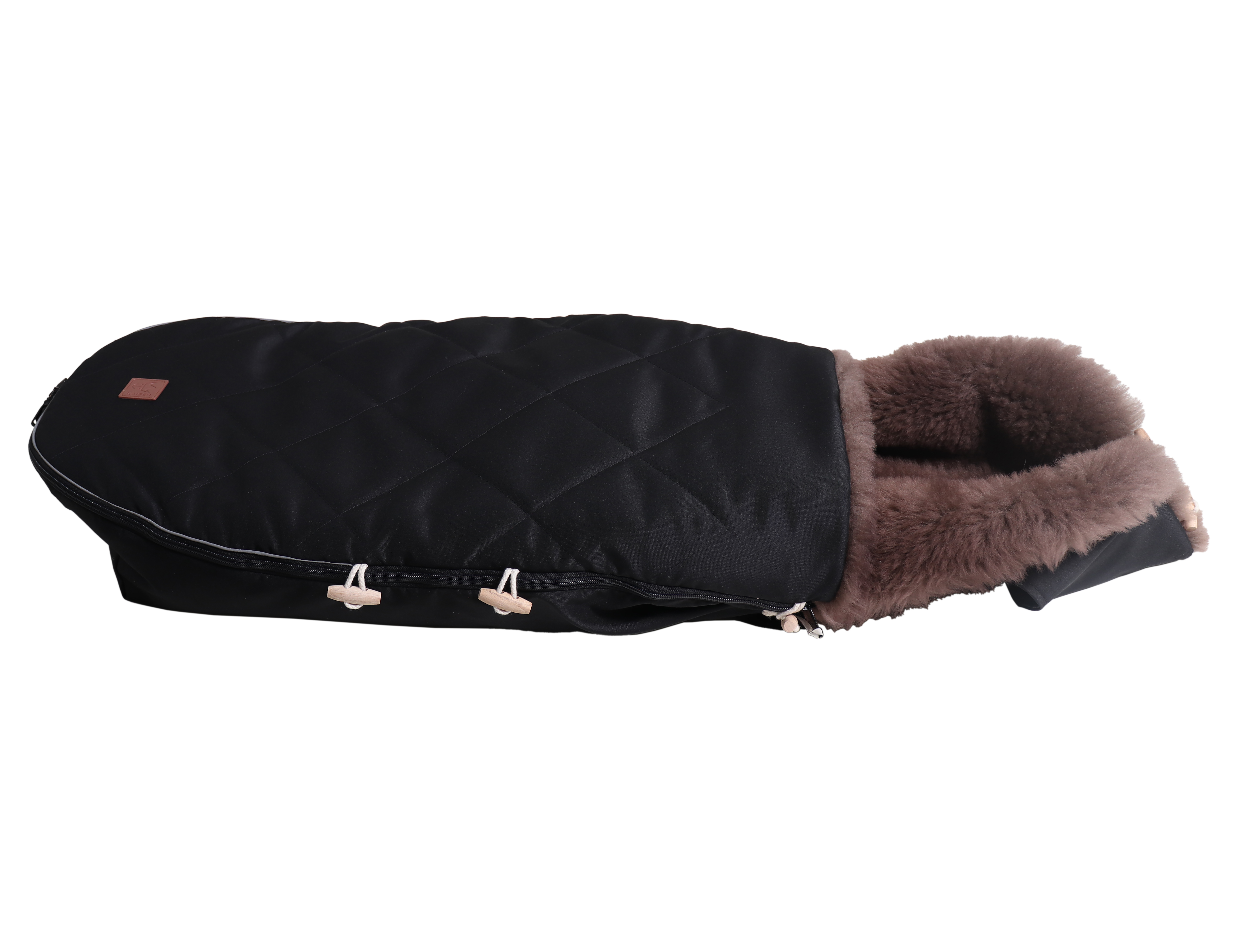 Fußsack mit beigem Lammfell-Innenfutter in der Farbe black liegt horizontal
