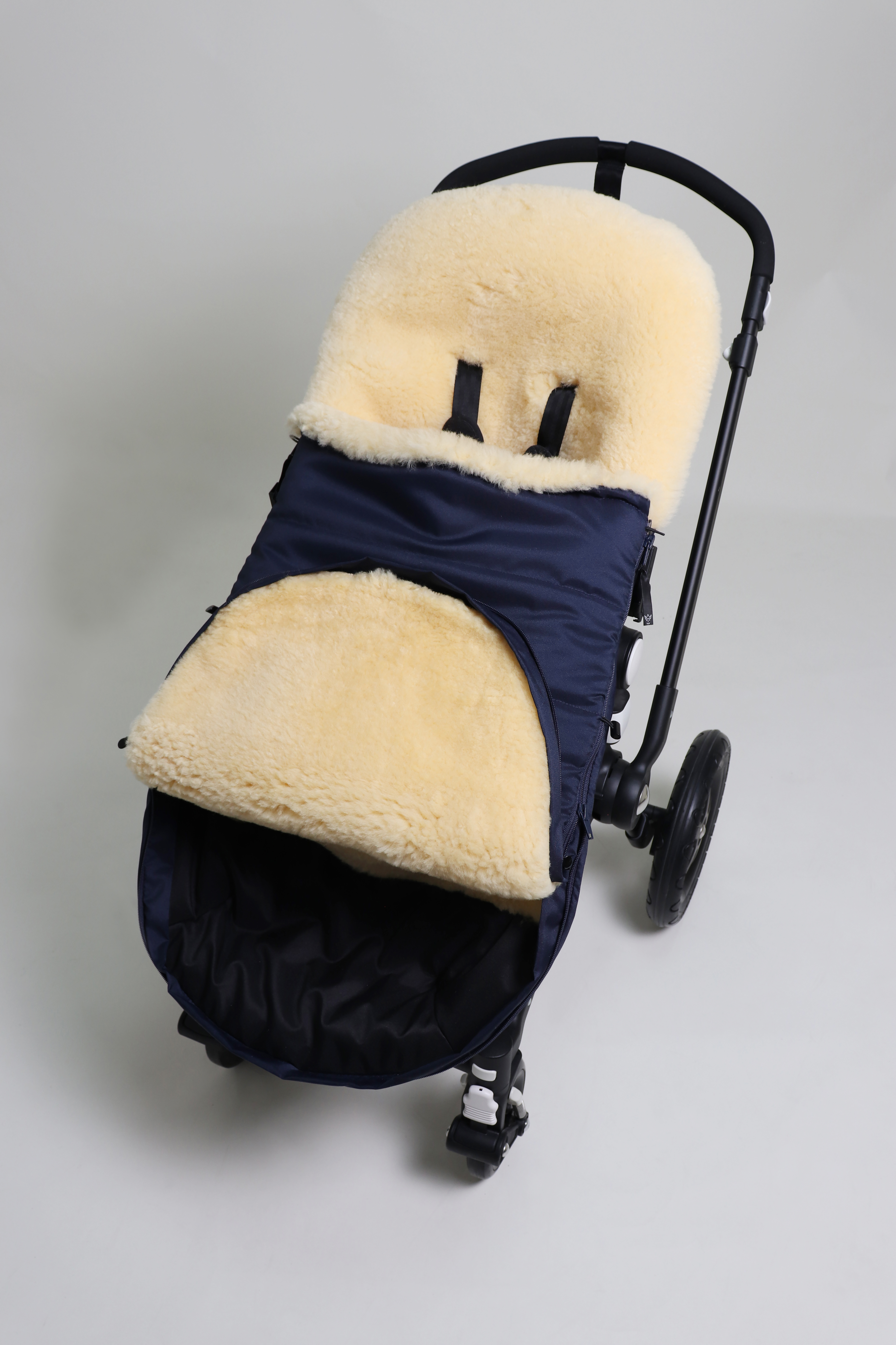 Fußsack mit dem Lammfell-Innenfutter in Navy in einem Kinderwagen eingesetzt