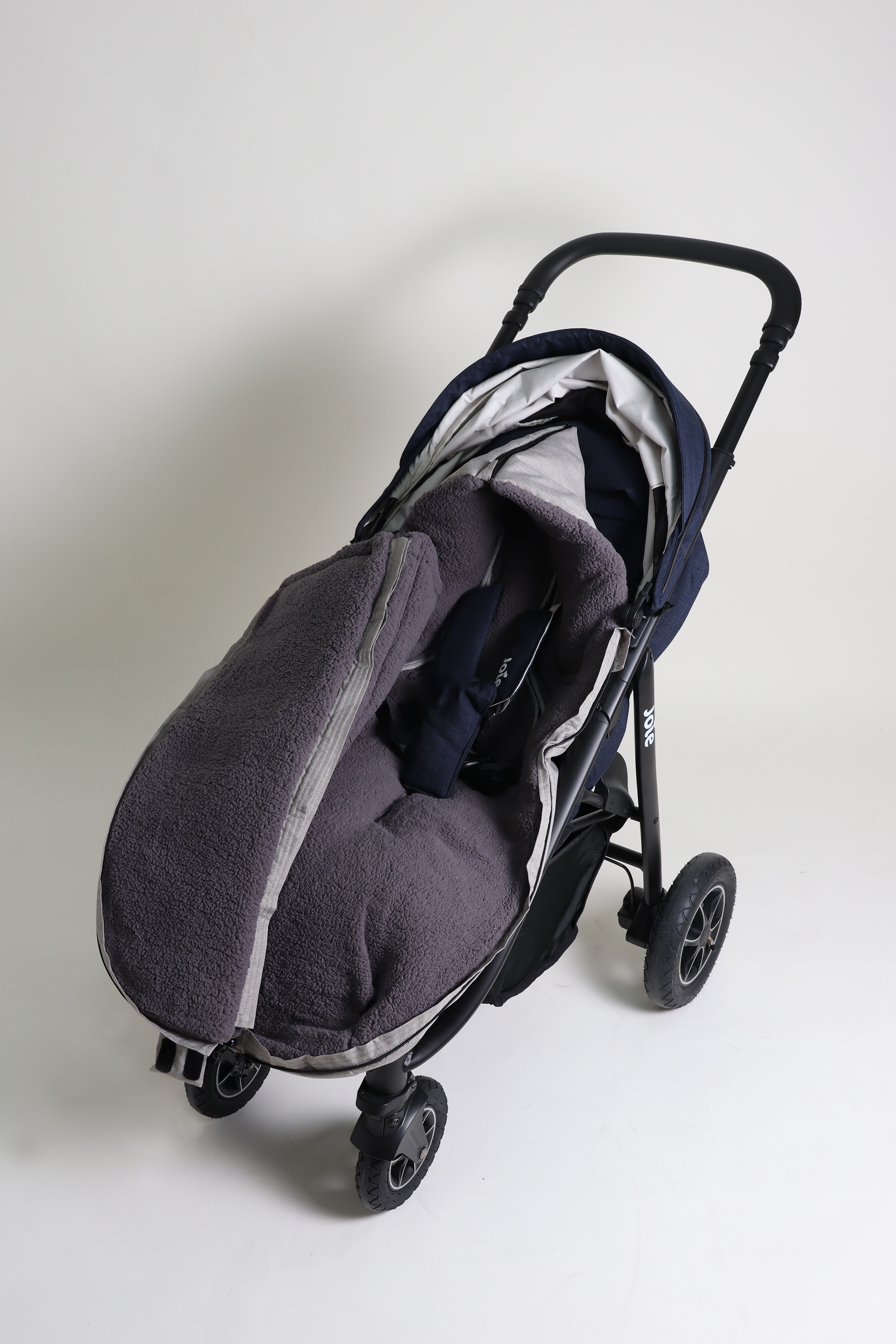 MILA Thermo-Fußsack Geschlossener Fußsack mit einem Sherpa-Futter in der Farbe light-grey melange ist in einem Kinderwagen eingesetzt