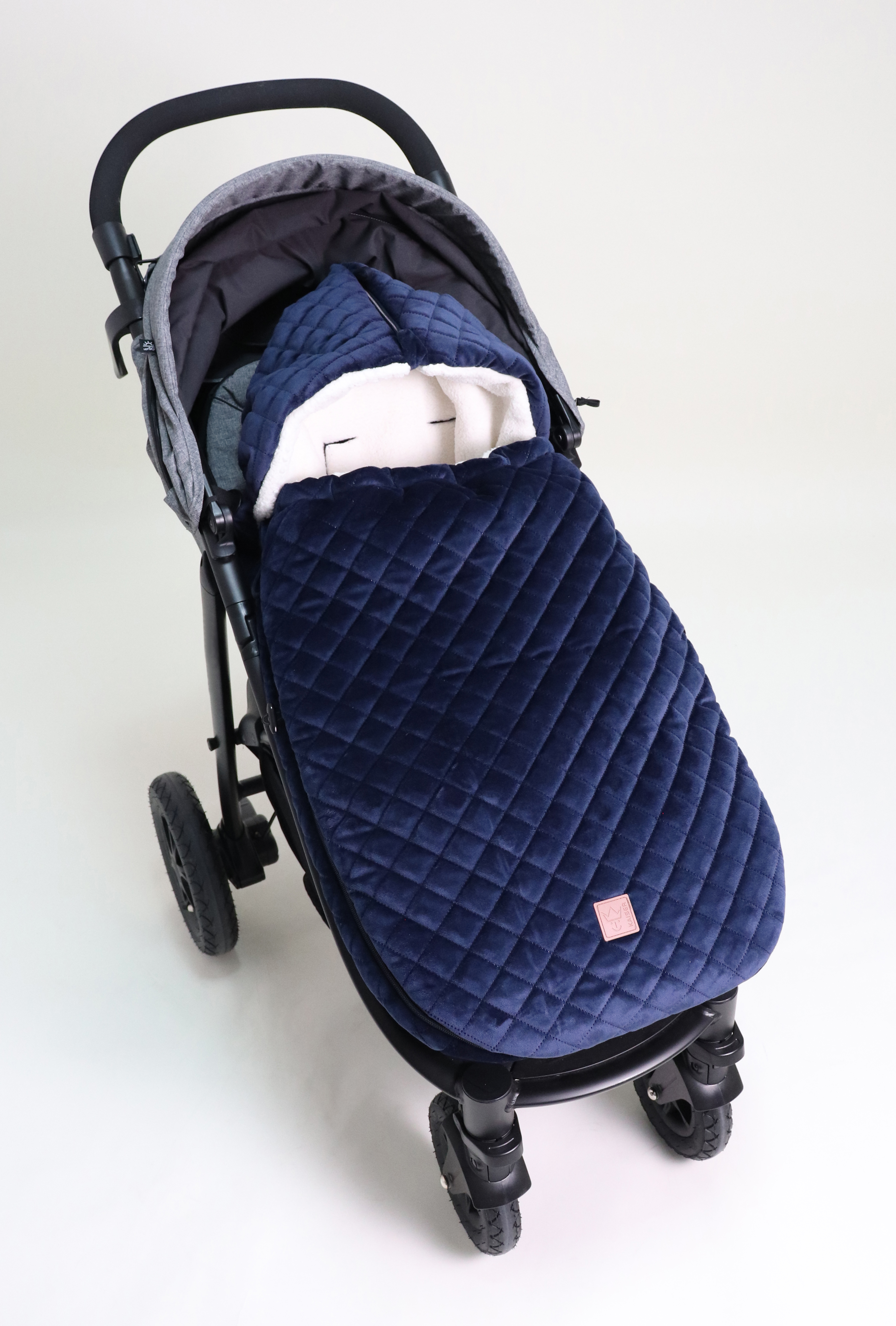 X-LARGE VELVET HOODY Fußsack in der Farbe navy ist in einem Kinderwagen eingesetzt