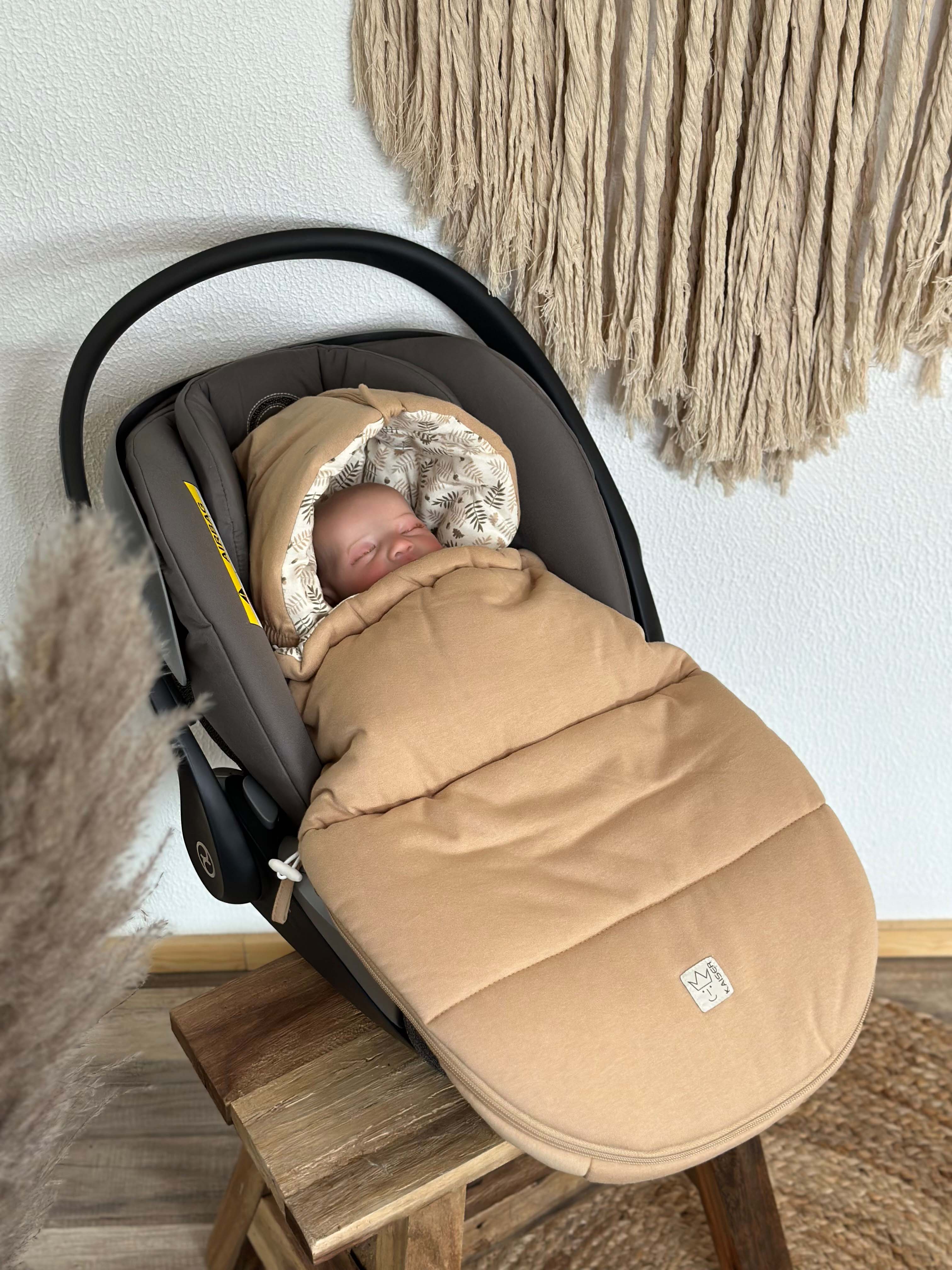 Baby im Autositz mit SMALL JERSEY HOODED Babyschalen Fußsack in der Farbe Butternut