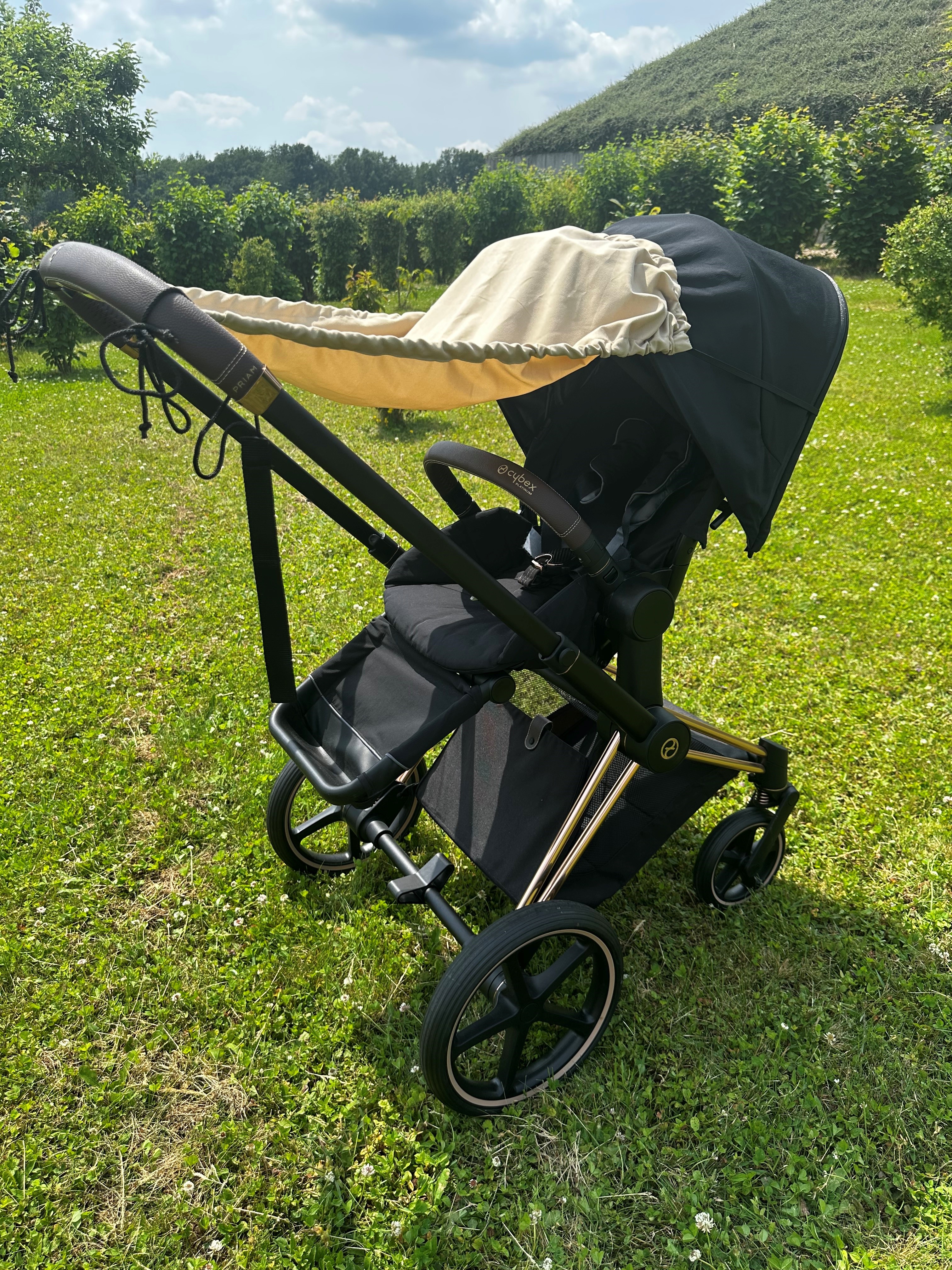 Sonnensegel in sand an Kinderwagen befestigt