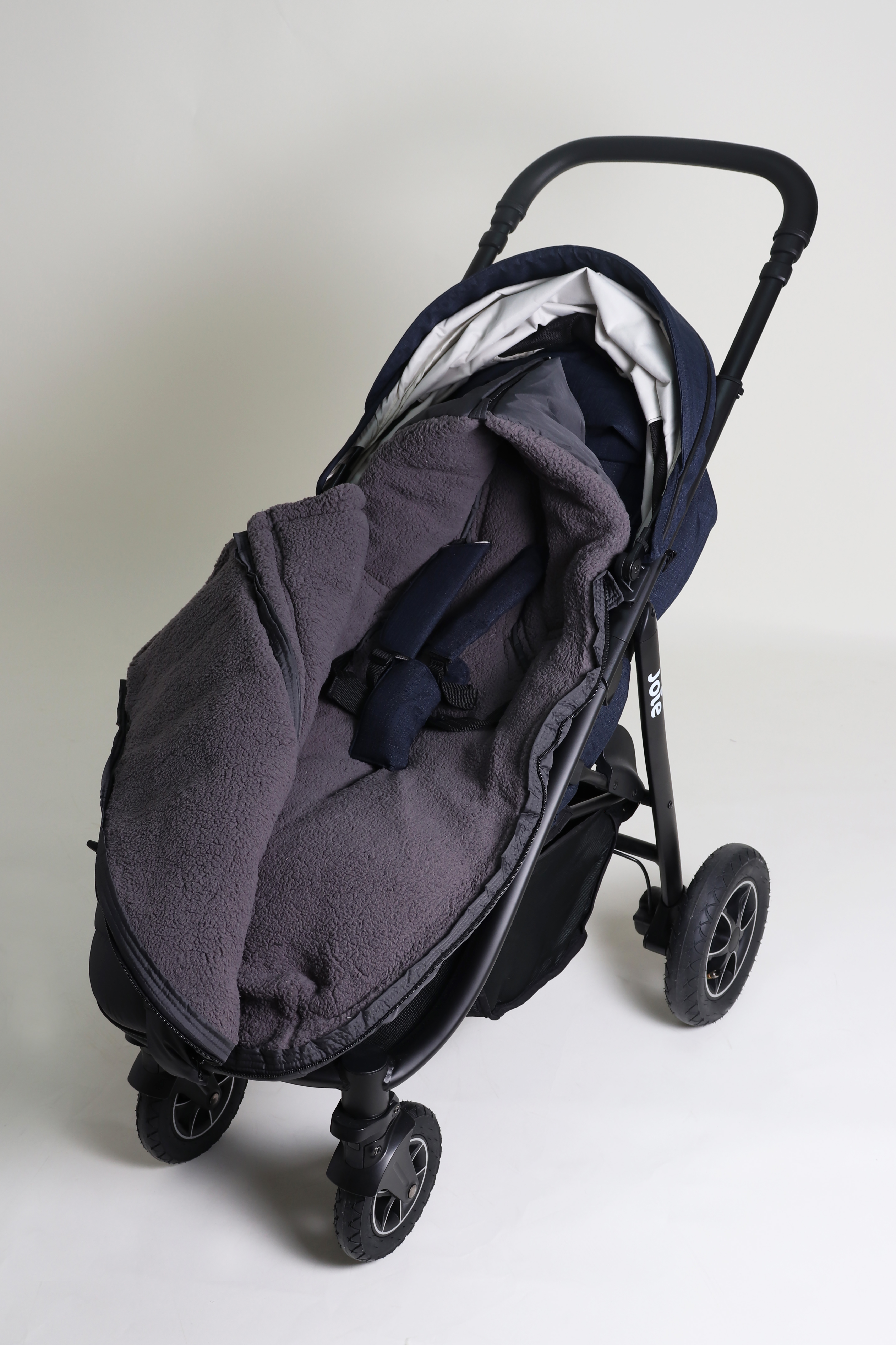 MILA Thermo-Fußsack Geschlossener Fußsack mit einem Sherpa-Futter in der Farbe anthrazit ist in einem Kinderwagen eingesetzt