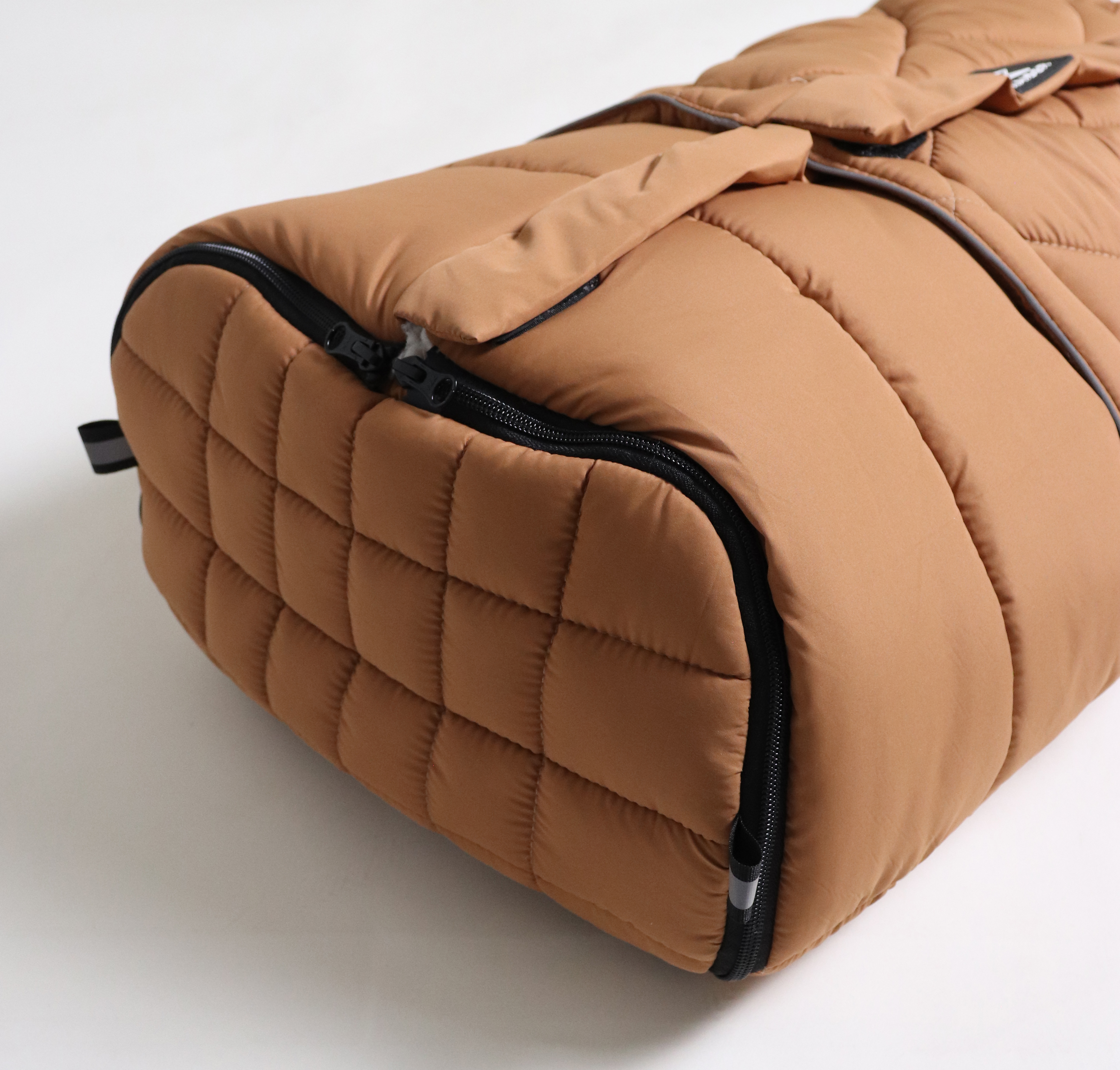 MOONY 2in1, Thermo Universal Fußsack Detailaufnahme eines Fußsacks in der Farbe Camel mit seitlichem Reißverschluss und gestepptem Bodenbereich.