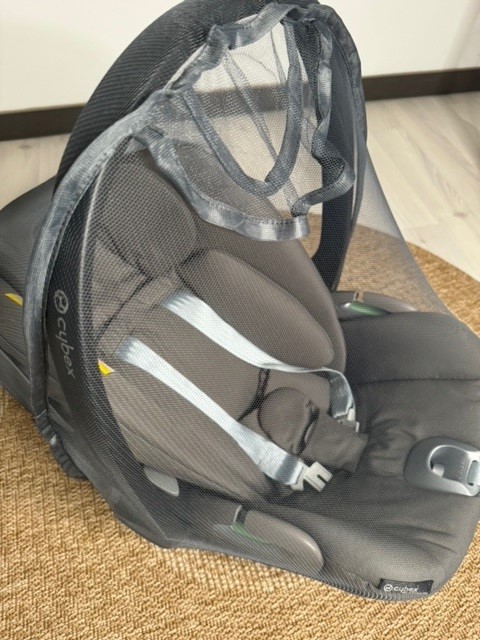 Moskitonetz an Babyschale befestigt