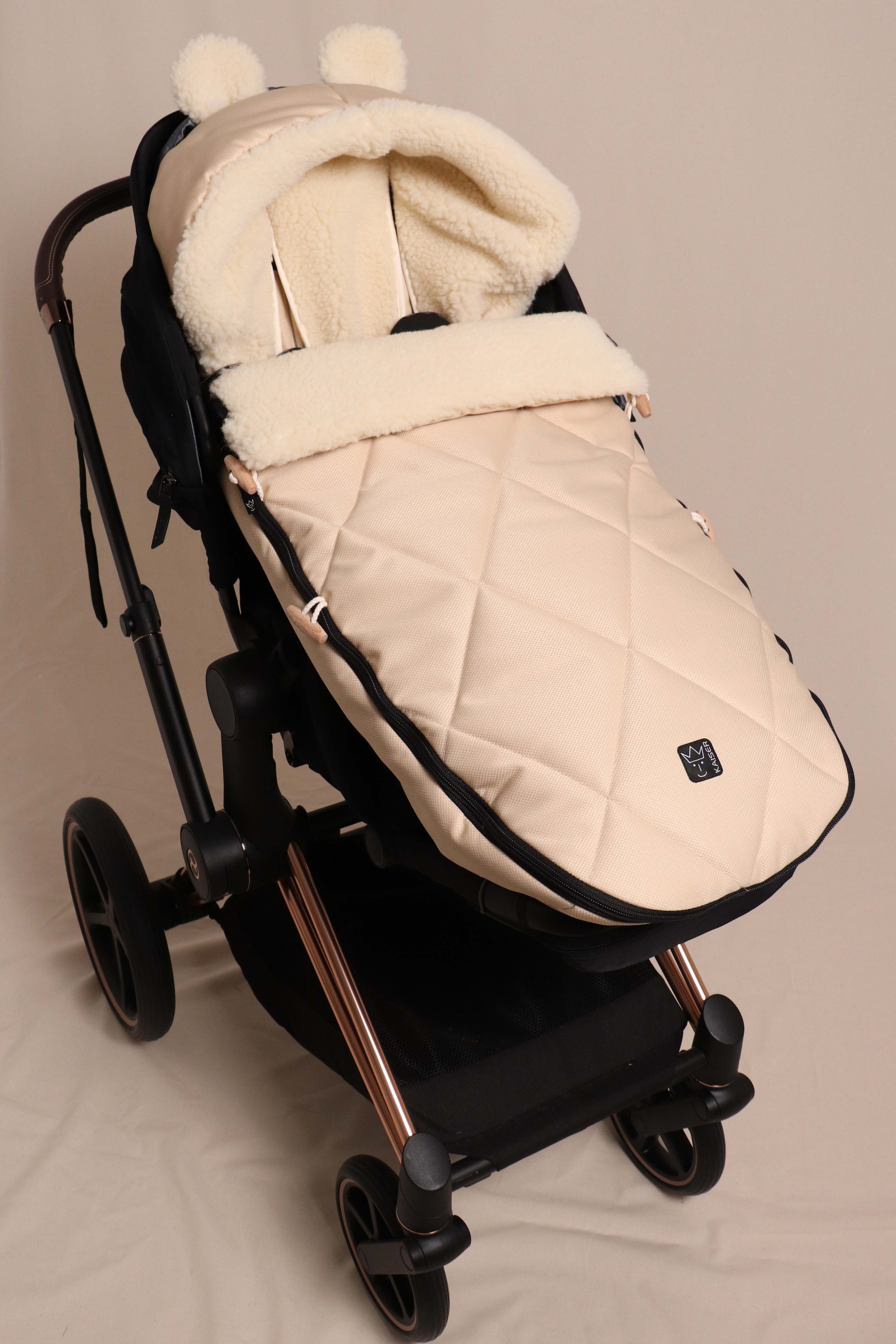 Geschlossener Fußsack in marzipan mit Schafwolle-Innenfutter ist in einem Kinderwagen eingesetzt
