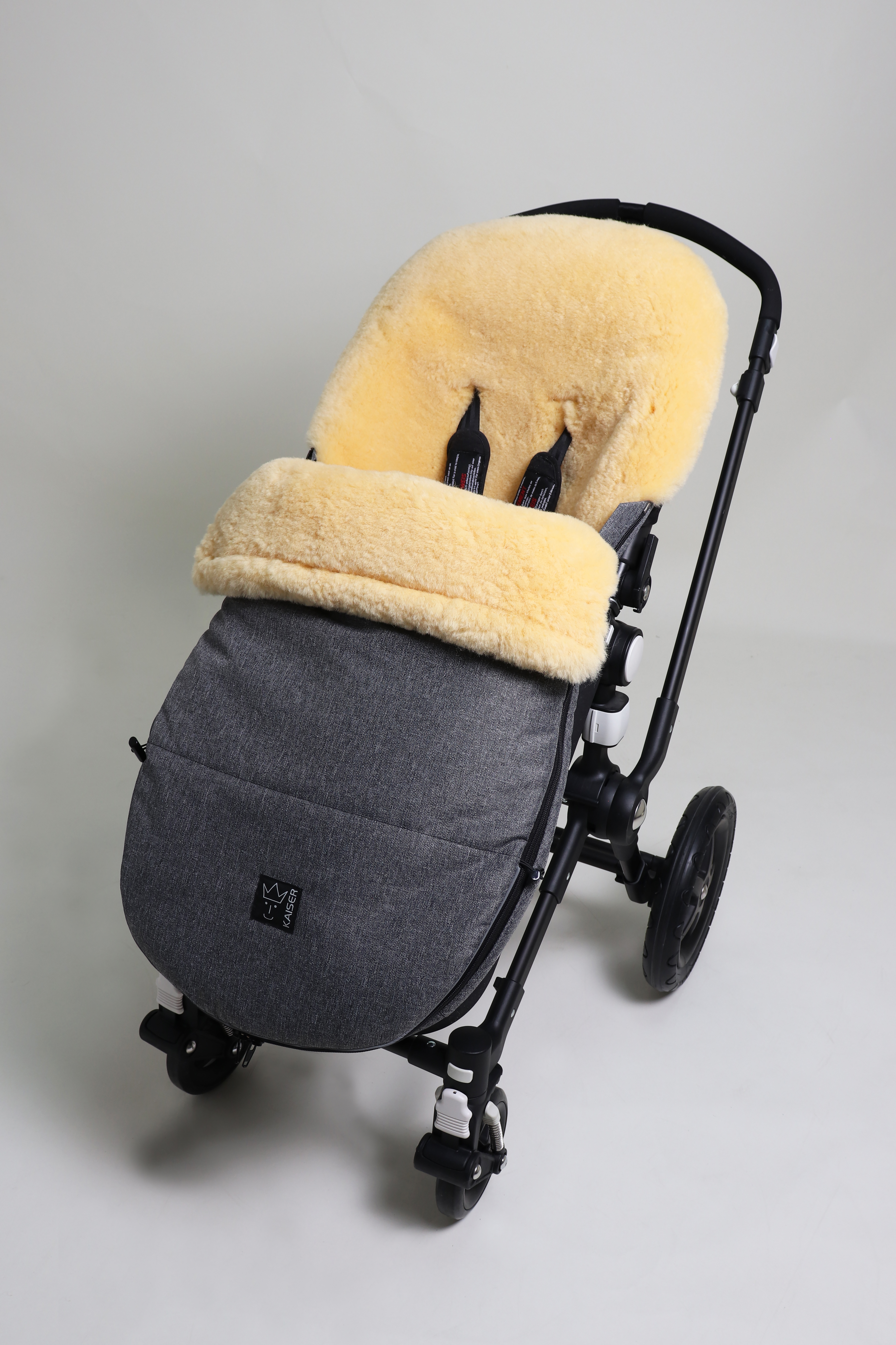 Fußsack mit dem Lammfell-Innenfutter in anthrazit-melange in einem Kinderwagen eingesetzt