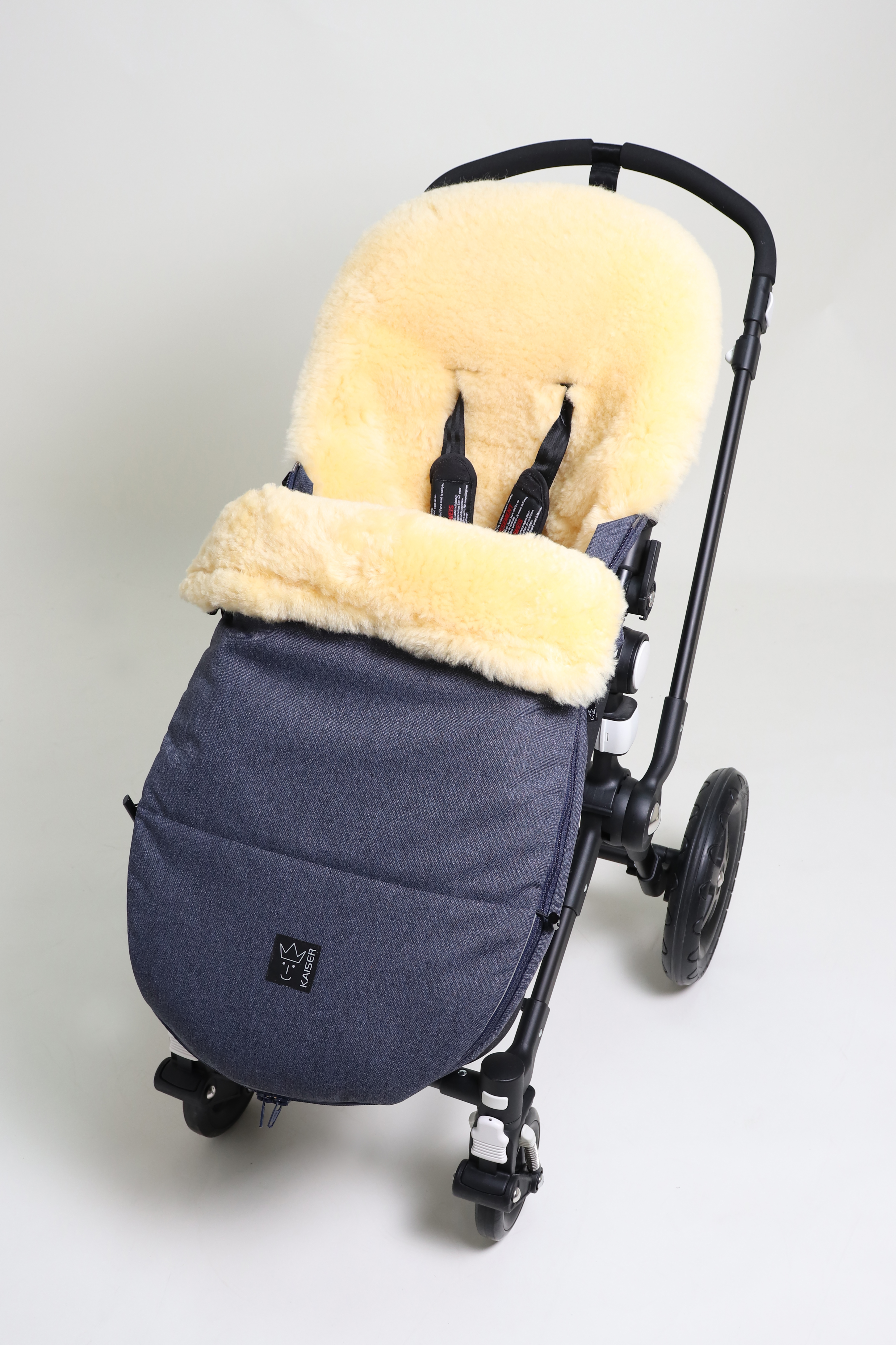 Fußsack mit dem Lammfell-Innenfutter in navy-melange in einem Kinderwagen eingesetzt