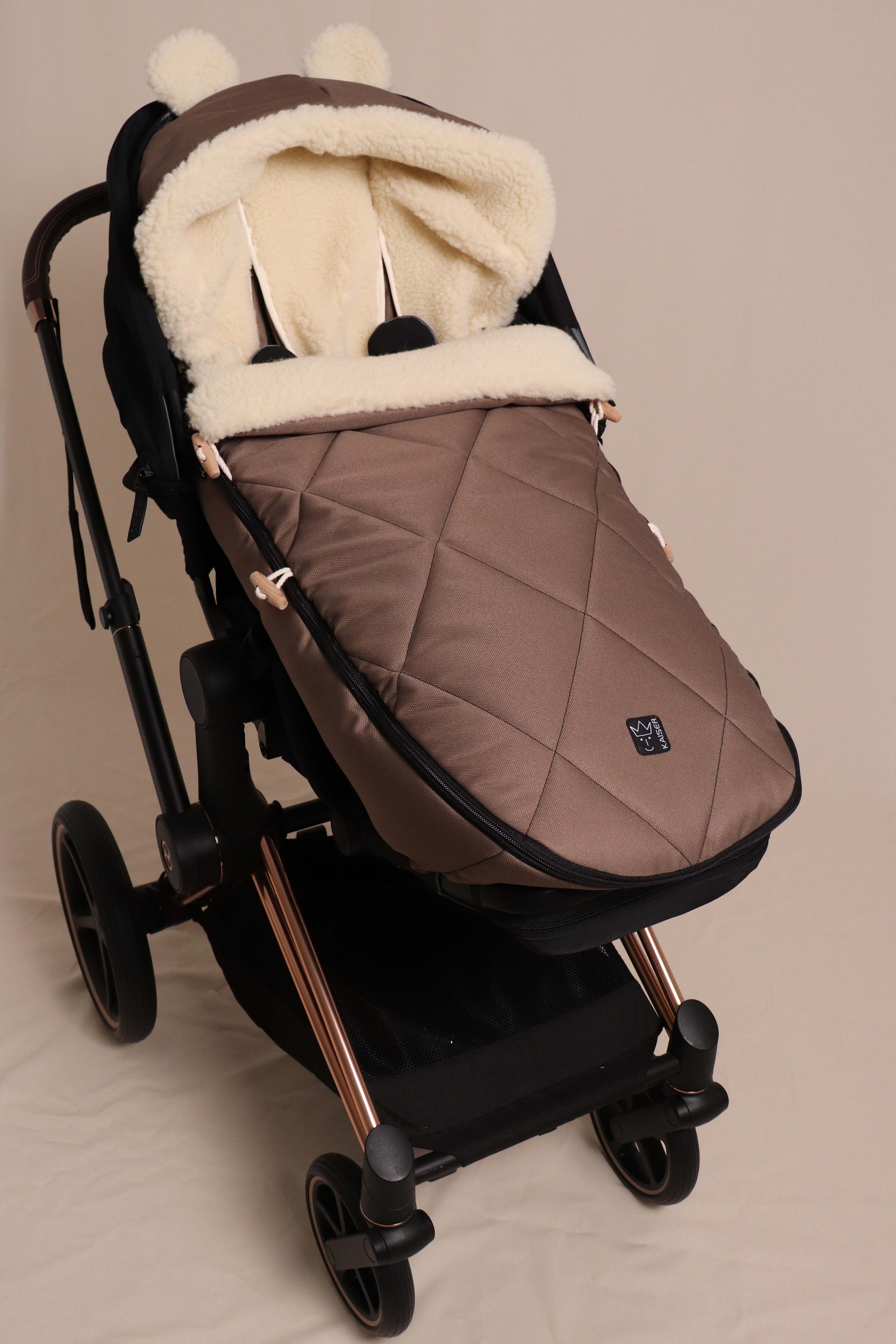 Geschlossener Fußsack in caribou mit Schafwolle-Innenfutter ist in einem Kinderwagen eingesetzt
