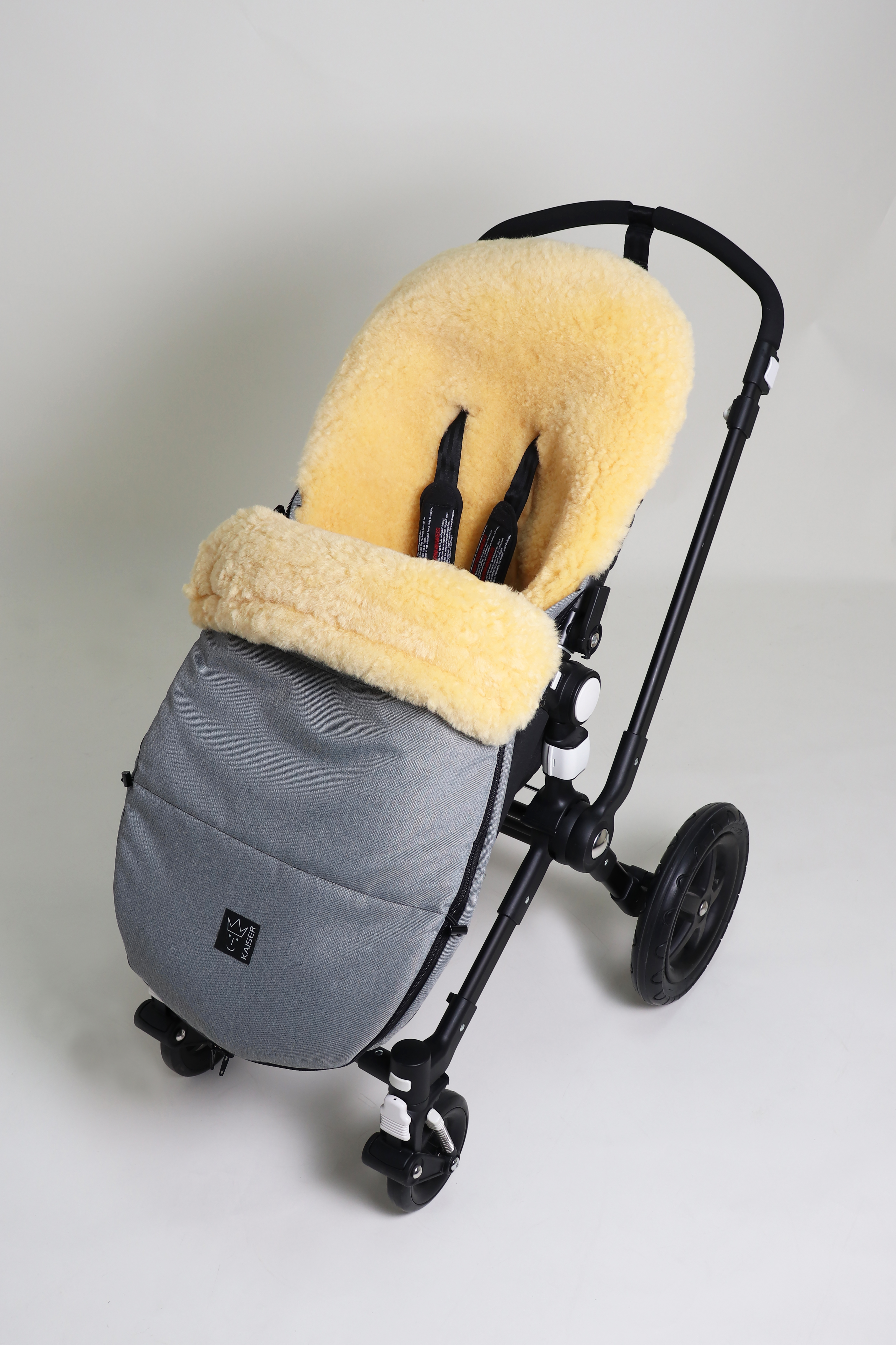 Fußsack mit dem Lammfell-Innenfutter in light-grey-melange in einem Kinderwagen eingesetzt