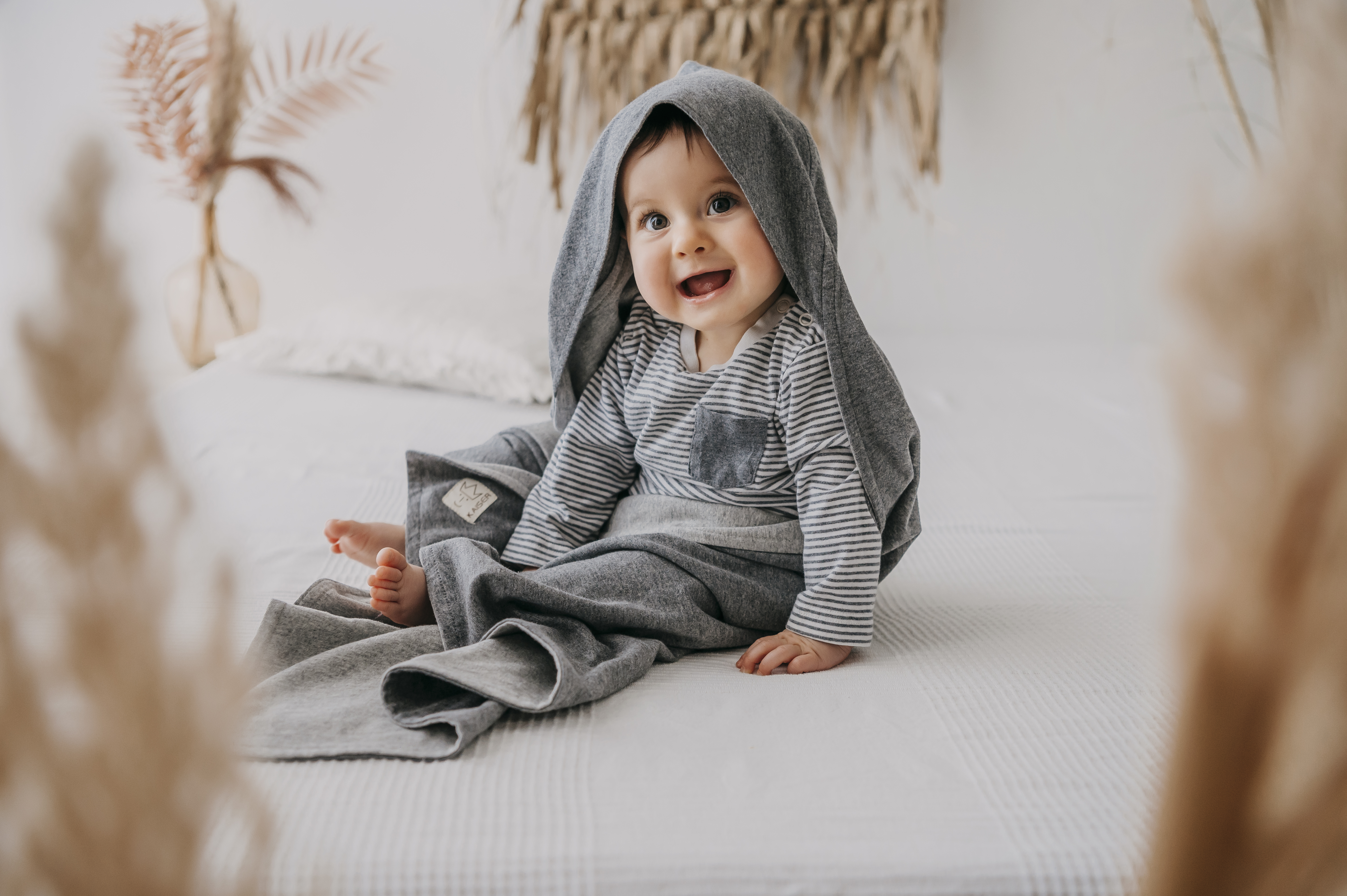 Lächelndes Baby eingewickelt in JERSEY Summer Beach Einschlagdecke in der Farbe dark Grey