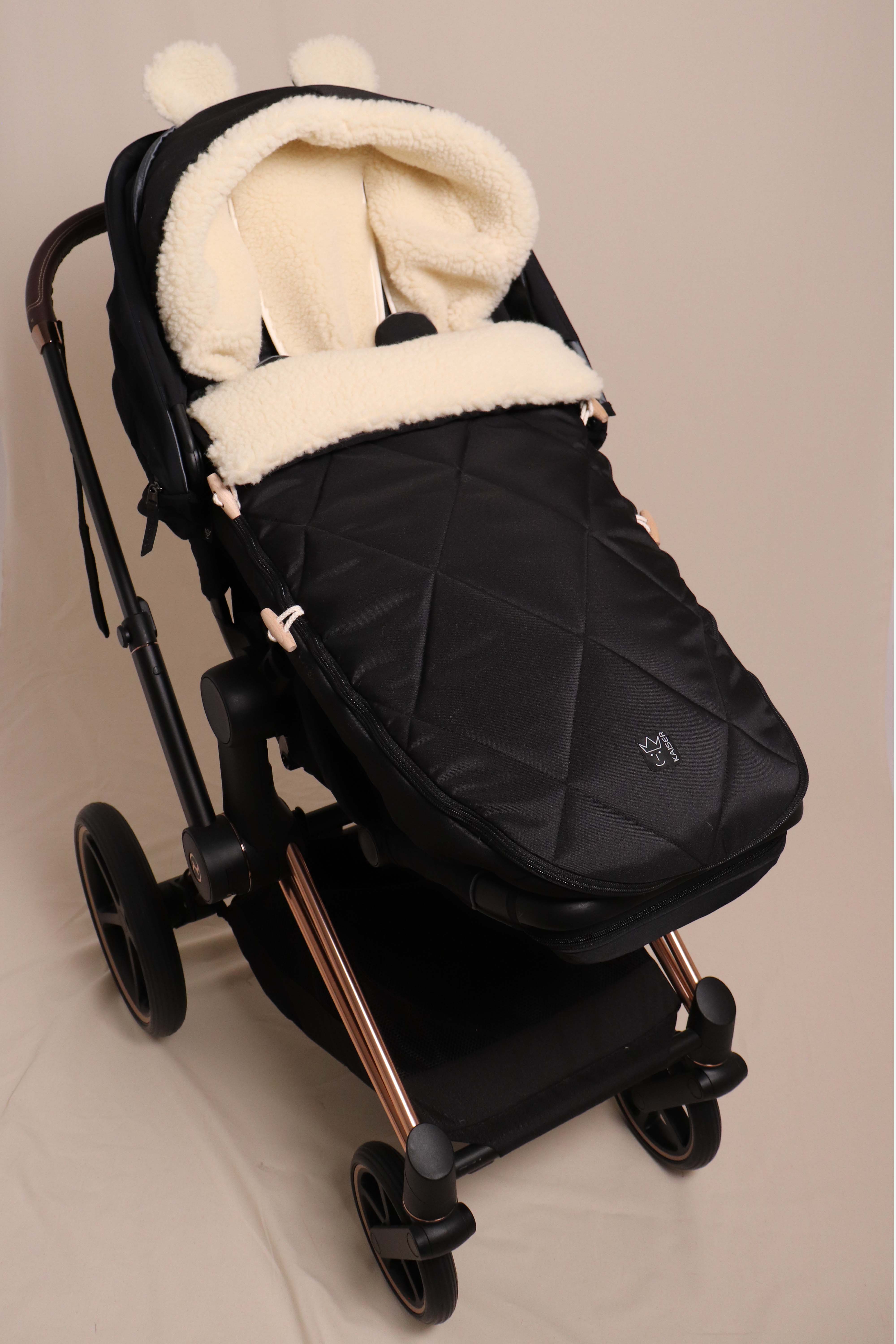 XL EARS WOOL - Kinderwagen Fußsack Geschlossener Fußsack in Schwarz mit Schafwolle-Innenfutter ist in einem Kinderwagen eingesetzt