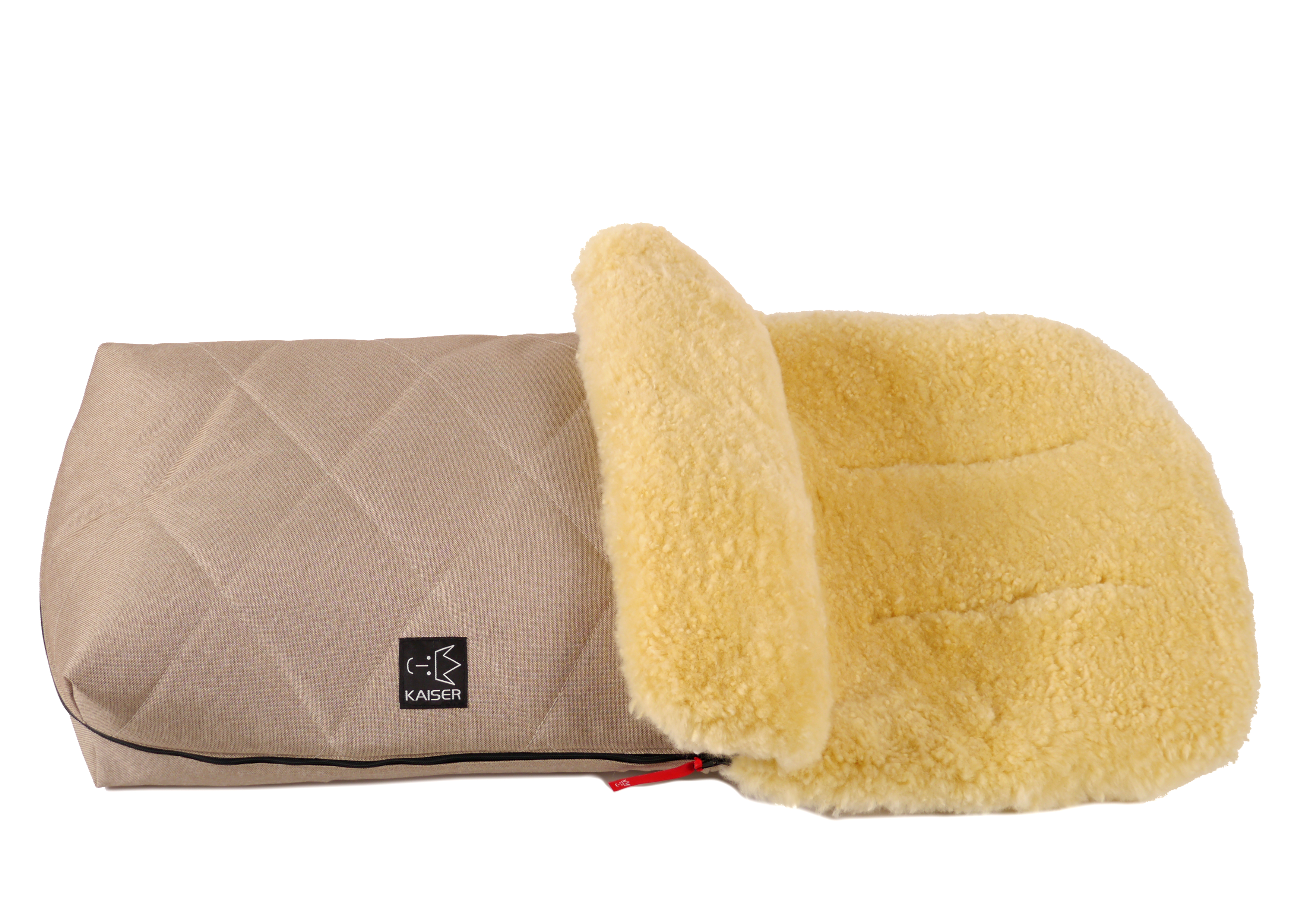 Fußsack mit dem Lammfell-Innenfutter in der Farbe sand melange und schwarzem „Kaiser“-Logo auf der Vorderseite liegt horizontal