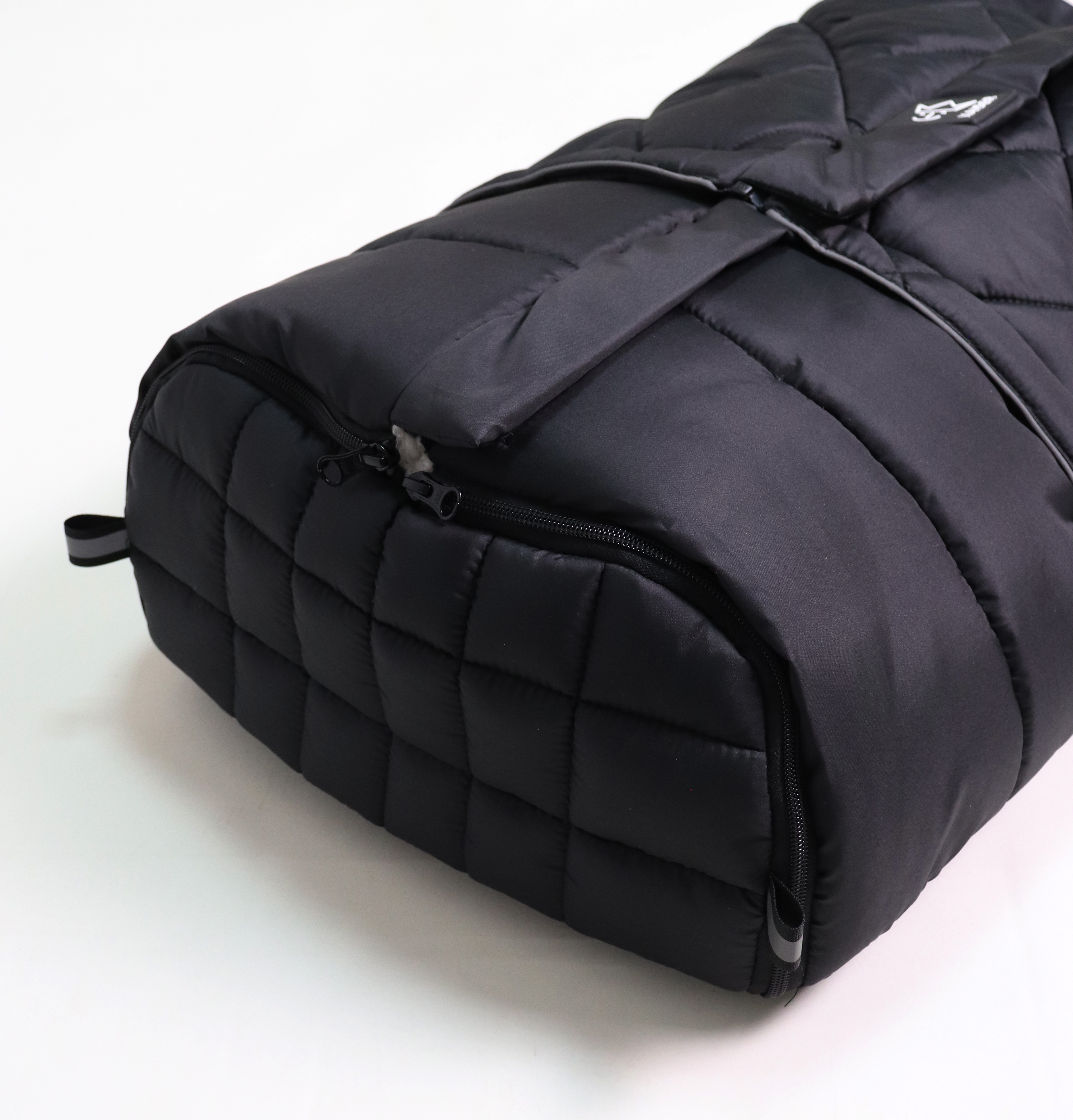 Detailaufnahme eines schwarzen Fußsacks mit seitlichem Reißverschluss und gestepptem Bodenbereich.