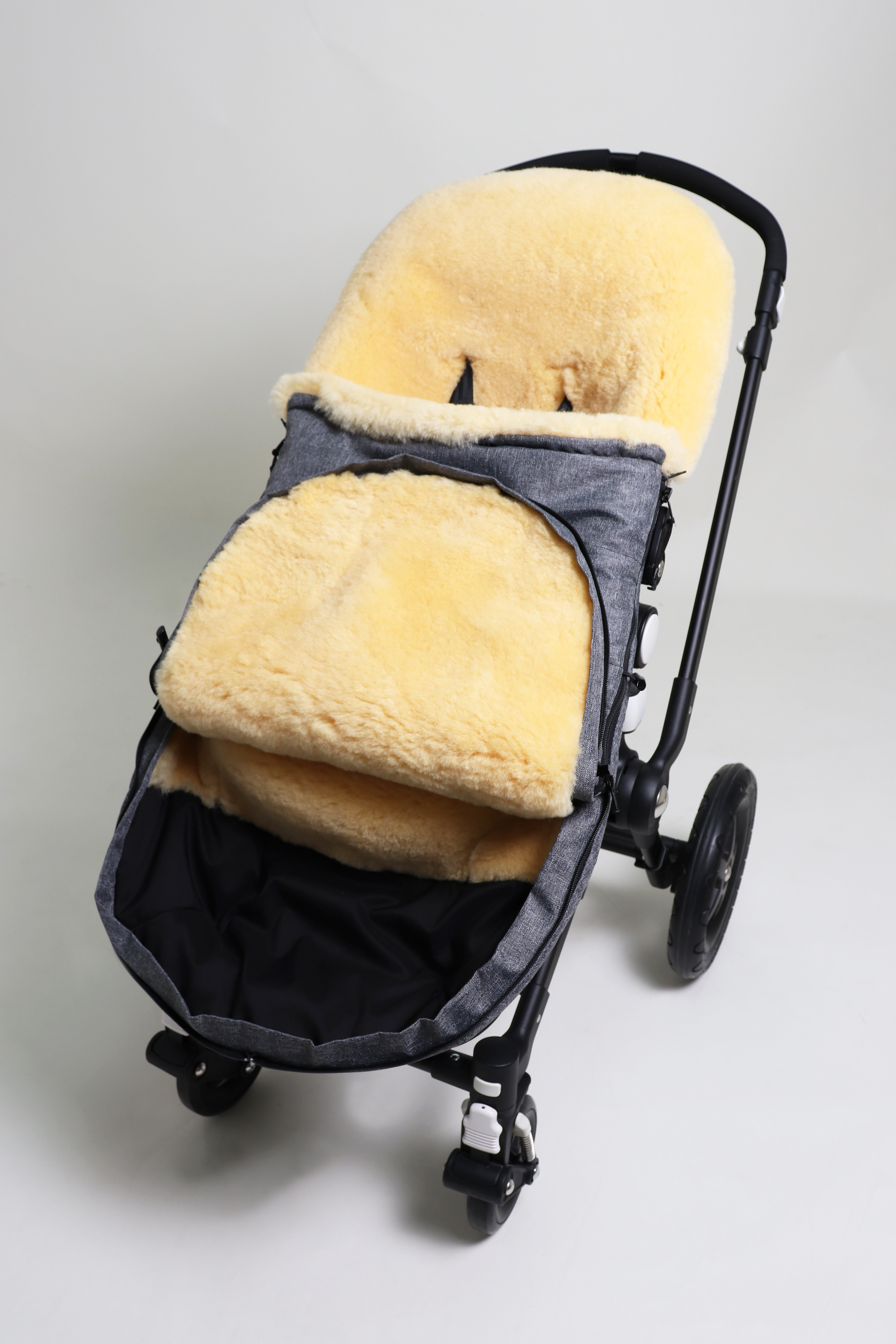 Fußsack mit dem Lammfell-Innenfutter in anthrazit-melange in einem Kinderwagen eingesetzt