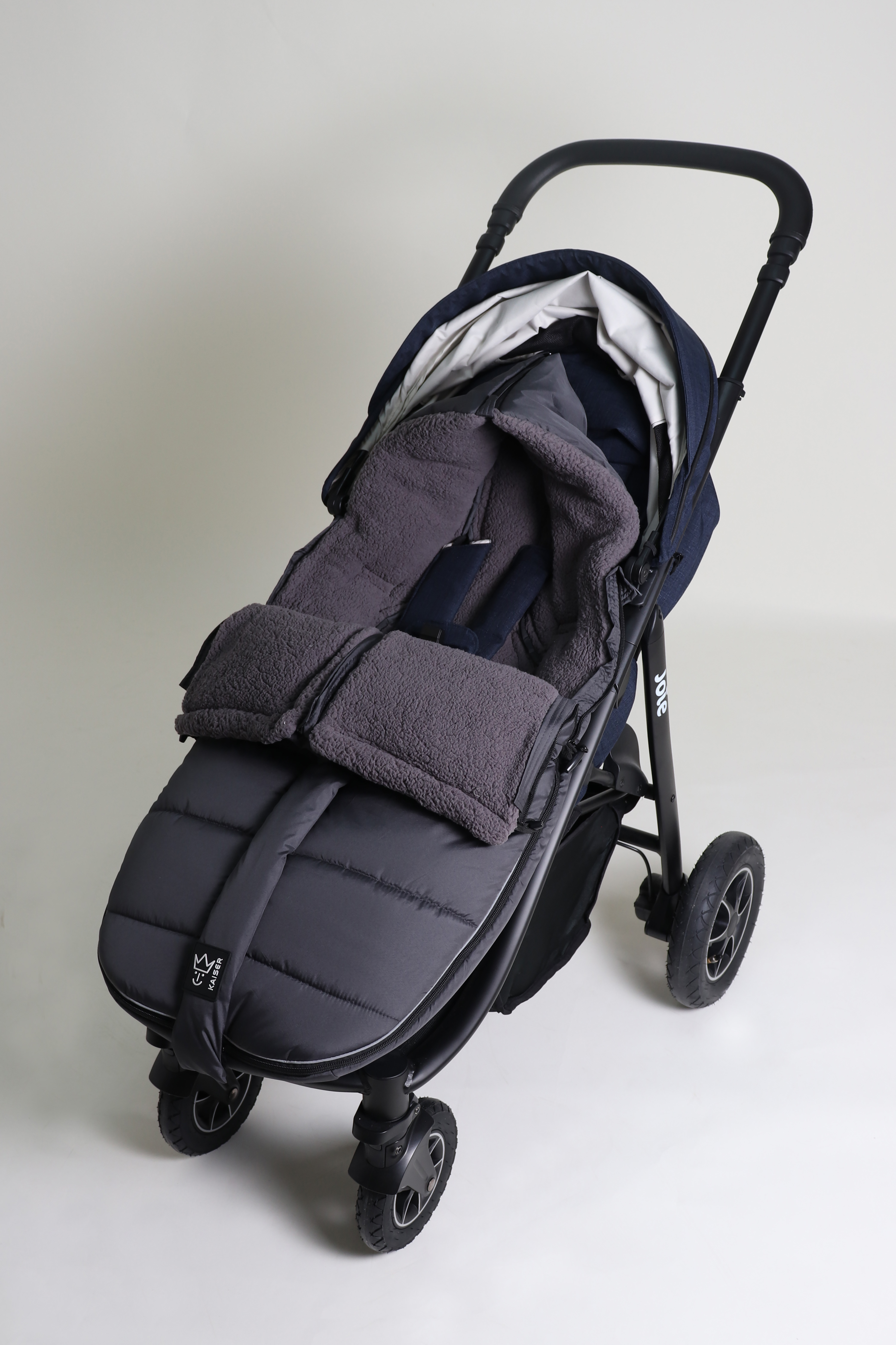 MILA Thermo-Fußsack Geschlossener Fußsack mit einem Sherpa-Futter in der Farbe anthrazit ist in einem Kinderwagen eingesetzt